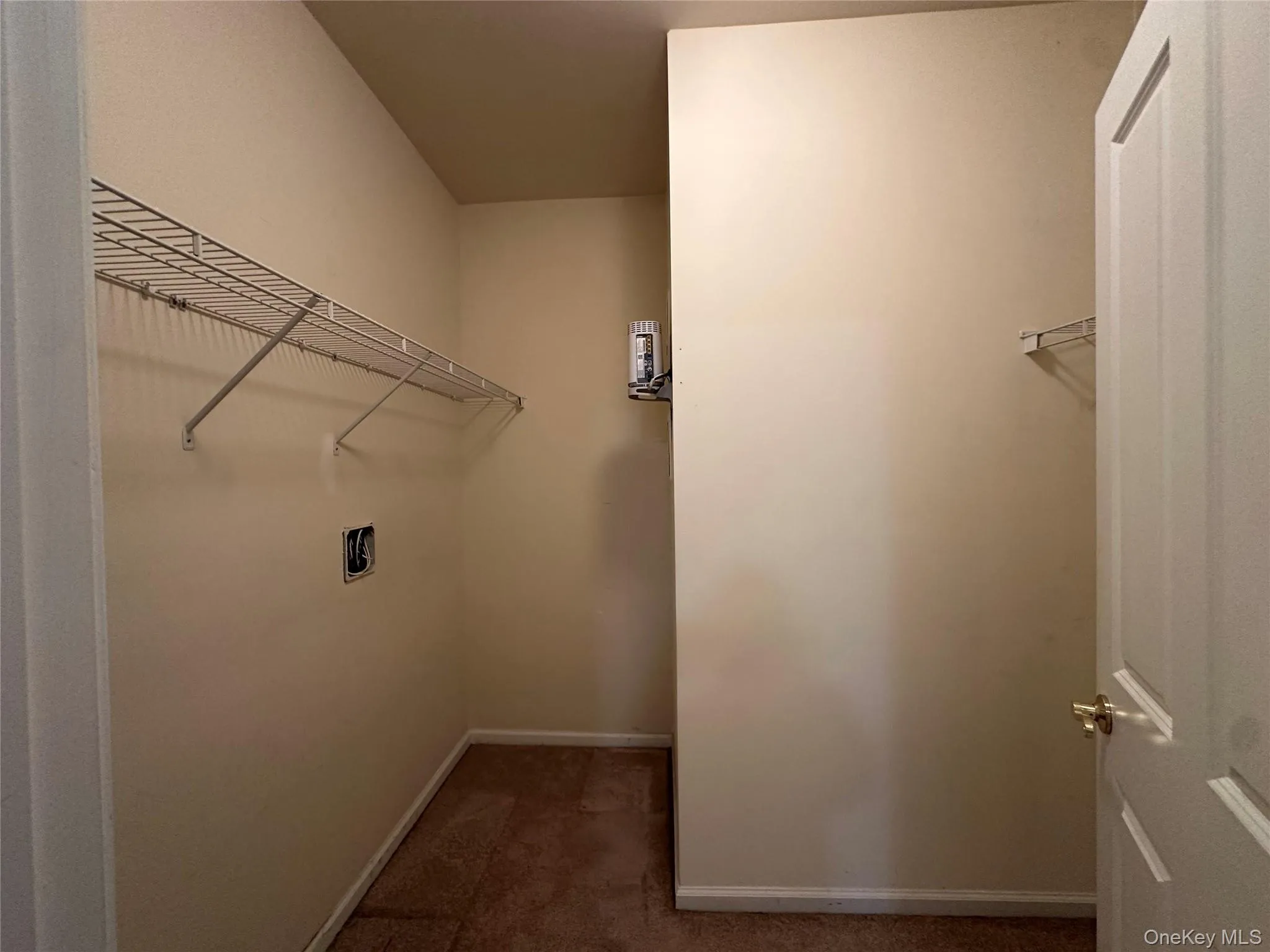 Spacious closet with dark colored carpet Spacious closet with dark colored carpet