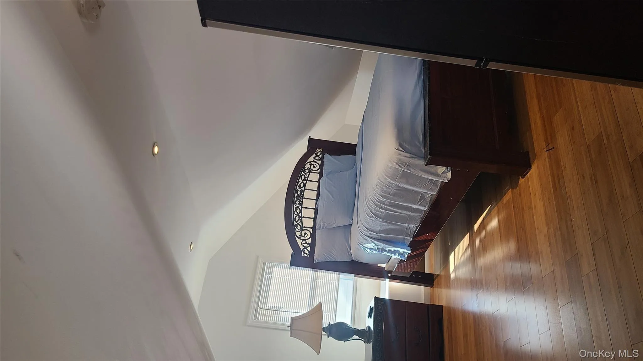 Bedroom featuring refrigerator, vaulted ceiling, light wood finished floors, and recessed lighting Bedroom featuring refrigerator, vaulted ceiling, light wood finished floors, and recessed lighting