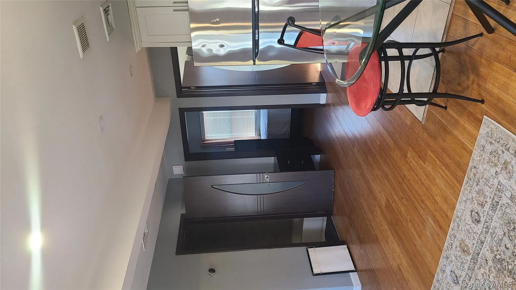 Kitchen featuring light wood finished floors, refrigerator, and white cabinets Kitchen featuring light wood finished floors, refrigerator, and white cabinets