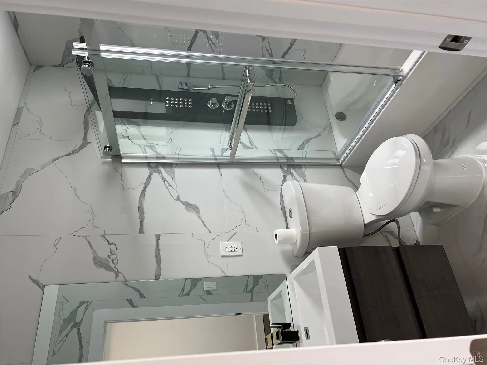 Full bath featuring vanity, combined bath / shower with glass door, and marble finish flooring Full bath featuring vanity, combined bath / shower with glass door, and marble finish flooring