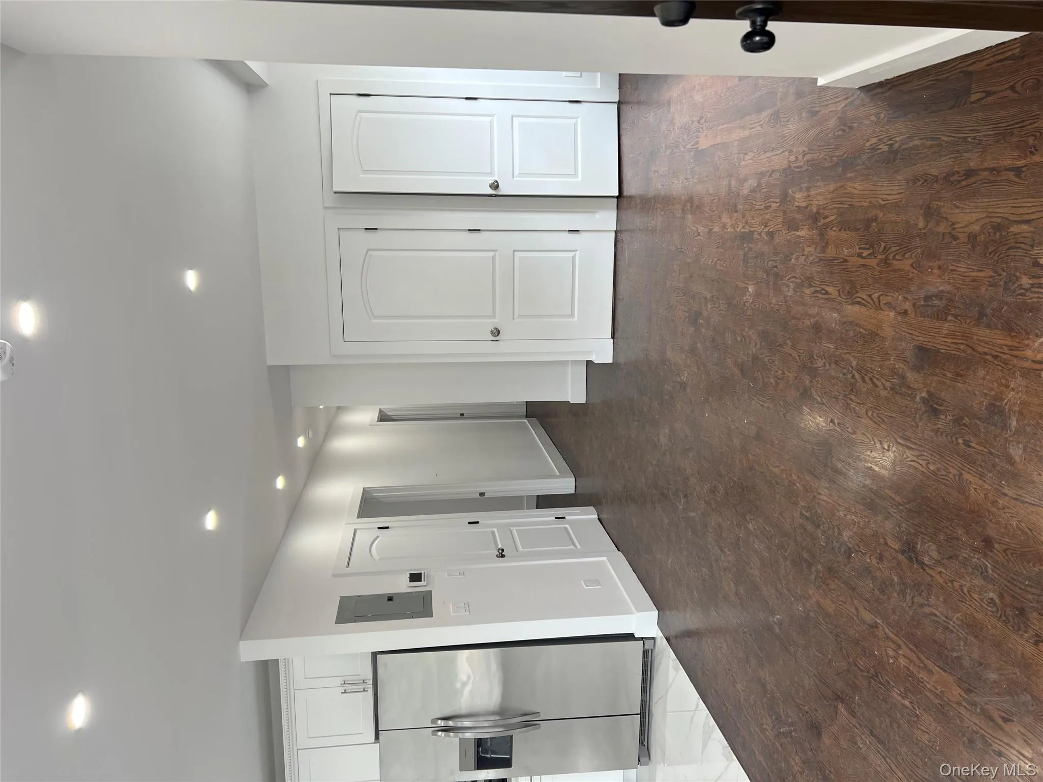 Unfurnished living room featuring recessed lighting, dark wood-type flooring, and electric panel Unfurnished living room featuring recessed lighting, dark wood-type flooring, and electric panel