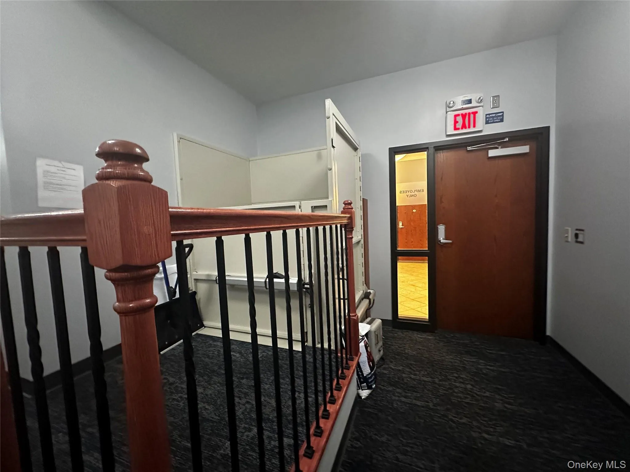 Corridor featuring an upstairs landing and dark carpet Corridor featuring an upstairs landing and dark carpet