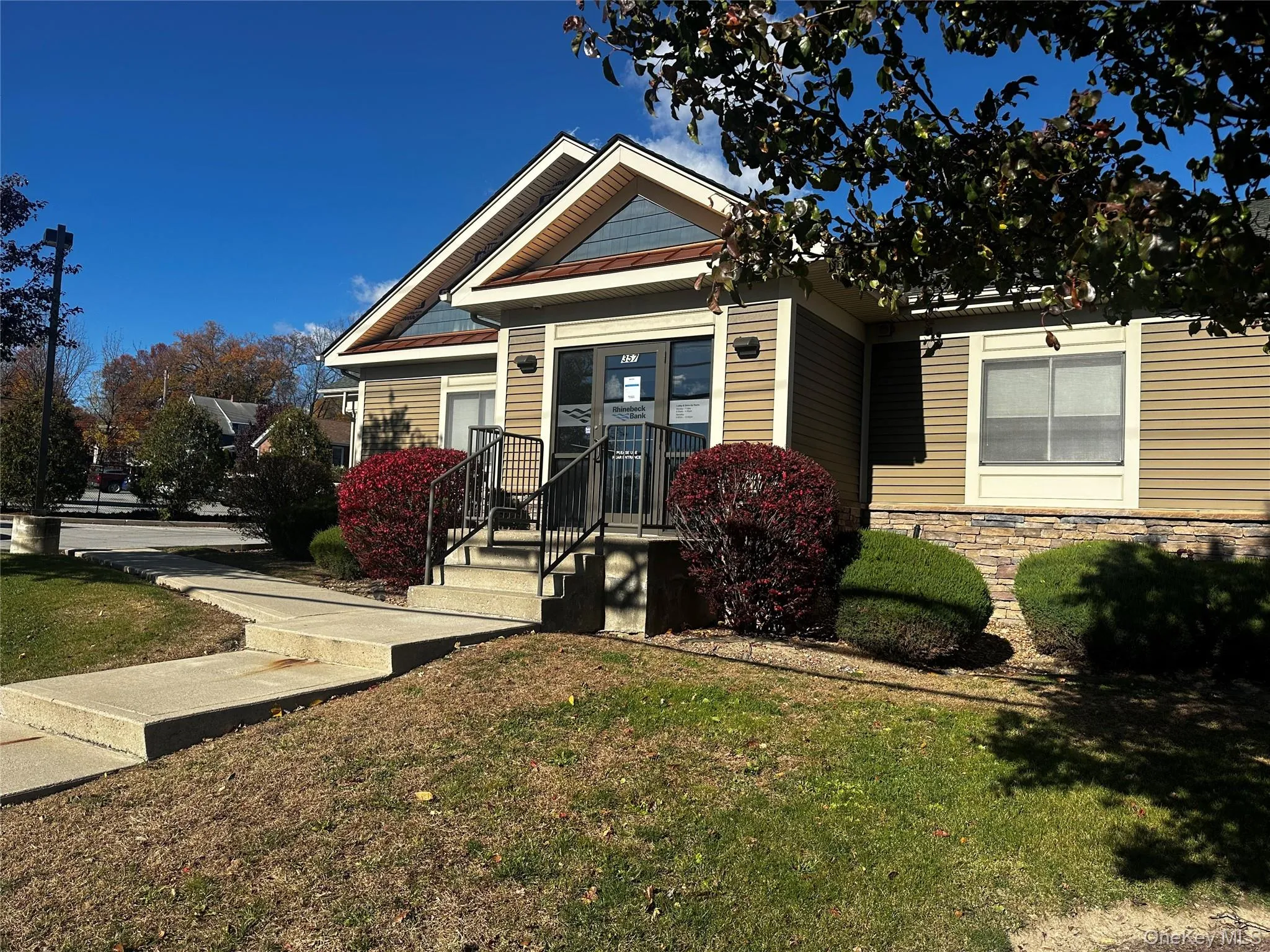 View of front facade with stone siding and a front yard View of front facade with stone siding and a front yard