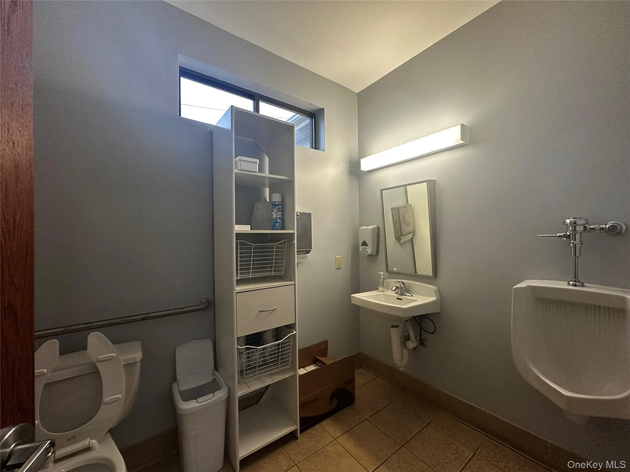 Bathroom featuring toilet and light tile patterned floors Bathroom featuring toilet and light tile patterned floors