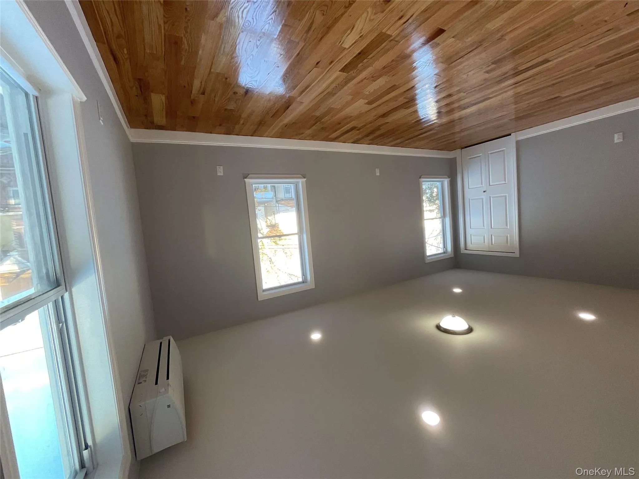 Spare room featuring light wood-style flooring, recessed lighting, and a wall mounted air conditioner Spare room featuring light wood-style flooring, recessed lighting, and a wall mounted air conditioner