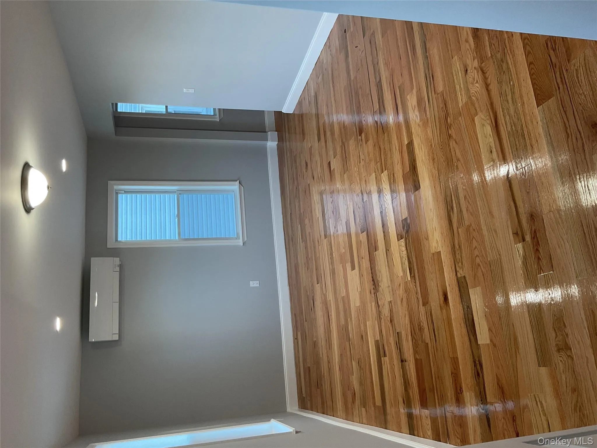 Empty room with light wood finished floors, a wall mounted AC, and recessed lighting Empty room with light wood finished floors, a wall mounted AC, and recessed lighting