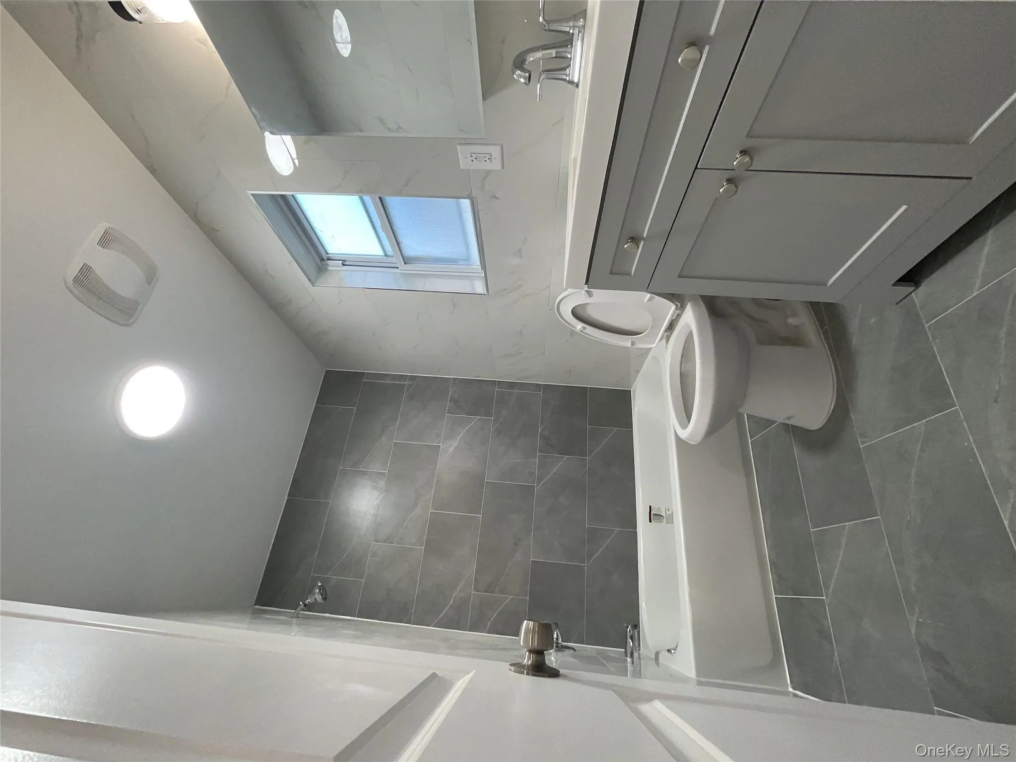 Bathroom with vanity, tub / shower combination, and tile walls Bathroom with vanity, tub / shower combination, and tile walls