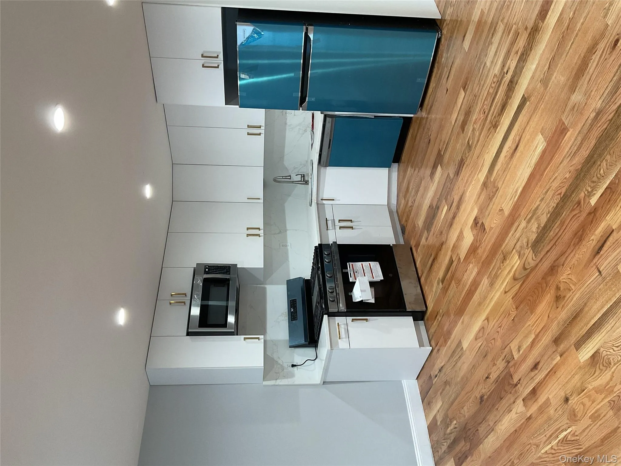Kitchen with stainless steel stove, white cabinetry, fridge, light wood-style floors, and recessed lighting Kitchen with stainless steel stove, white cabinetry, fridge, light wood-style floors, and recessed lighting