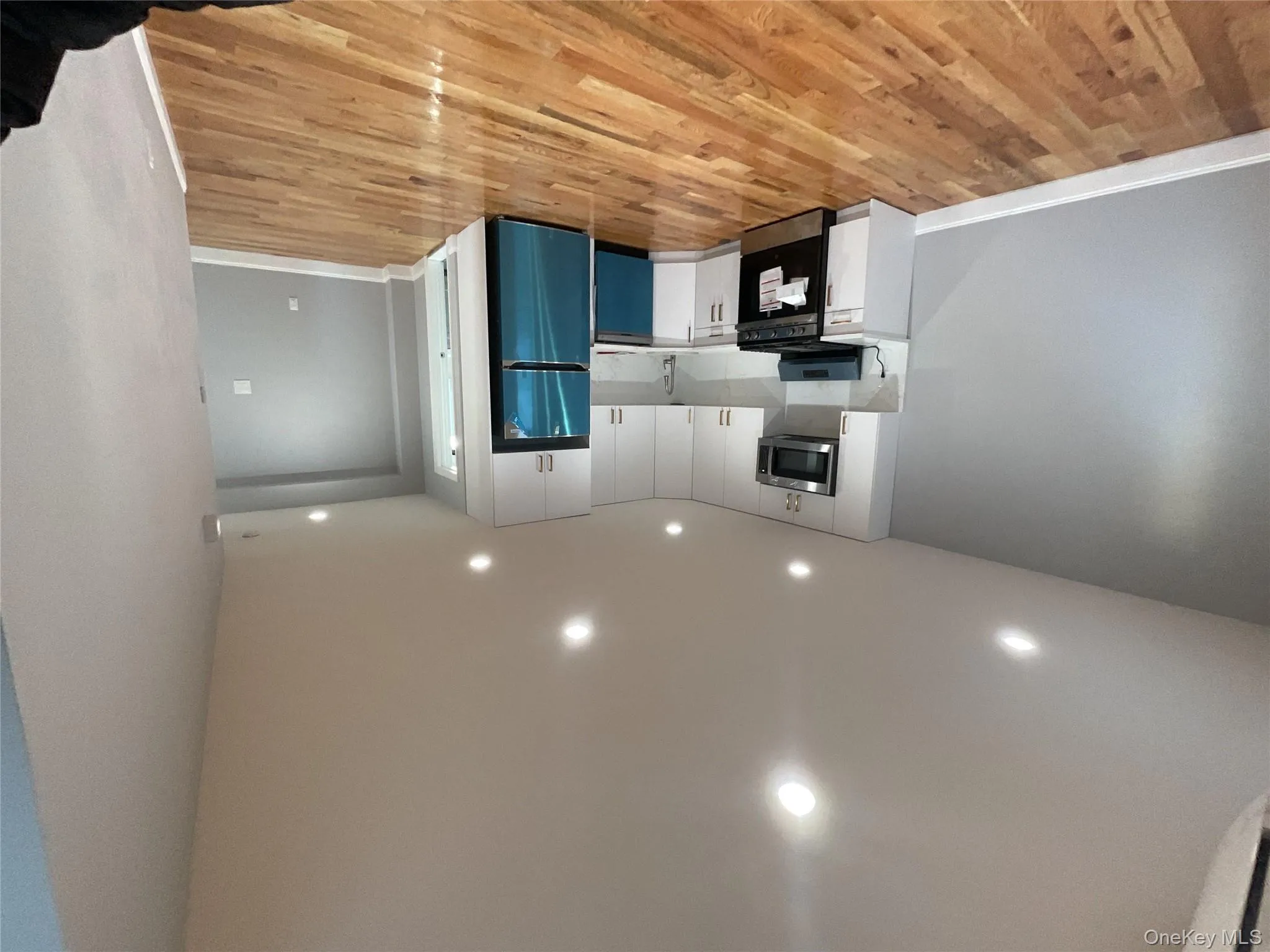 Kitchen featuring light countertops, range, white cabinetry, recessed lighting, and fridge Kitchen featuring light countertops, range, white cabinetry, recessed lighting, and fridge