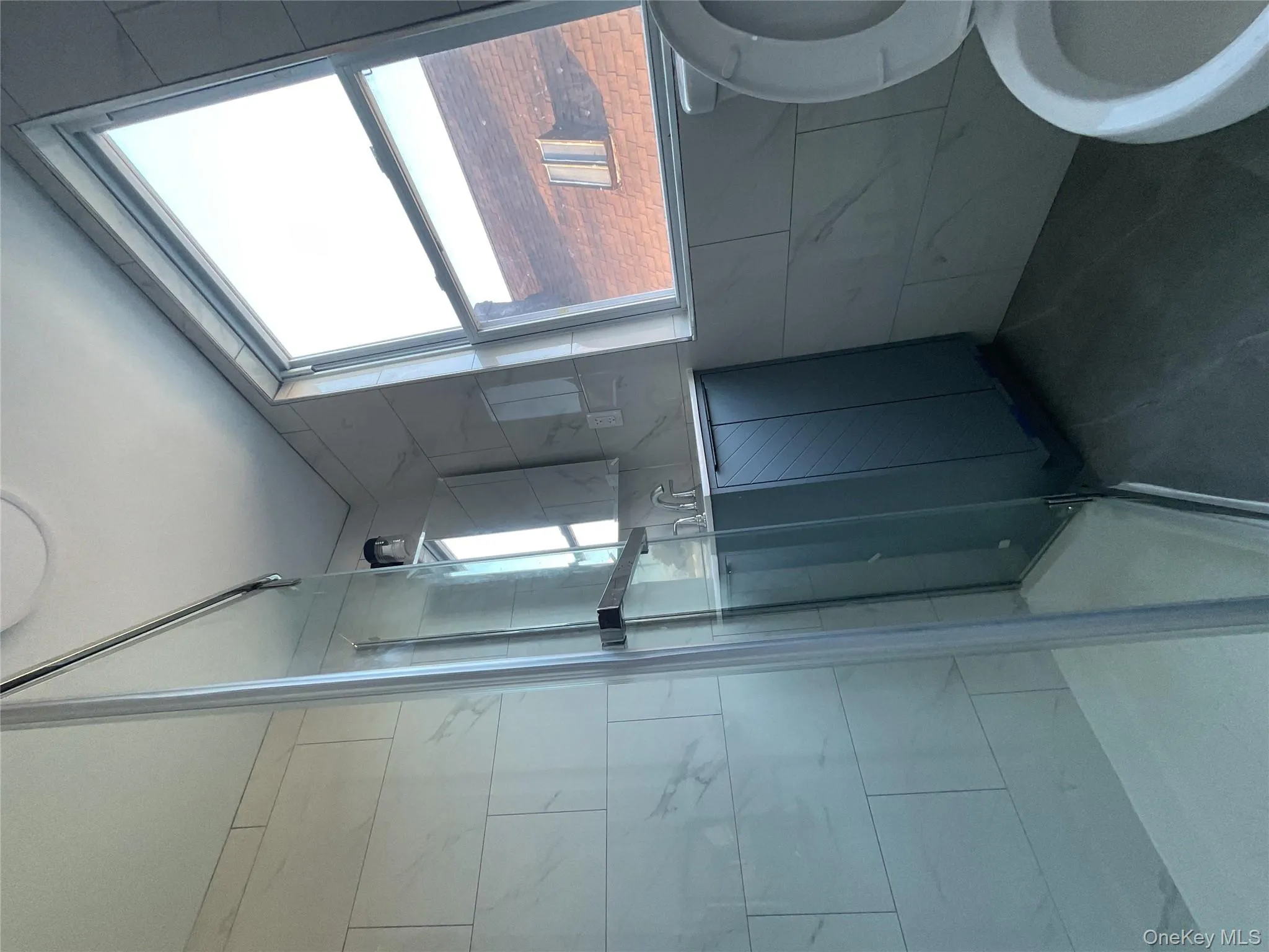 Bathroom with a shower stall, vanity, and tile walls Bathroom with a shower stall, vanity, and tile walls