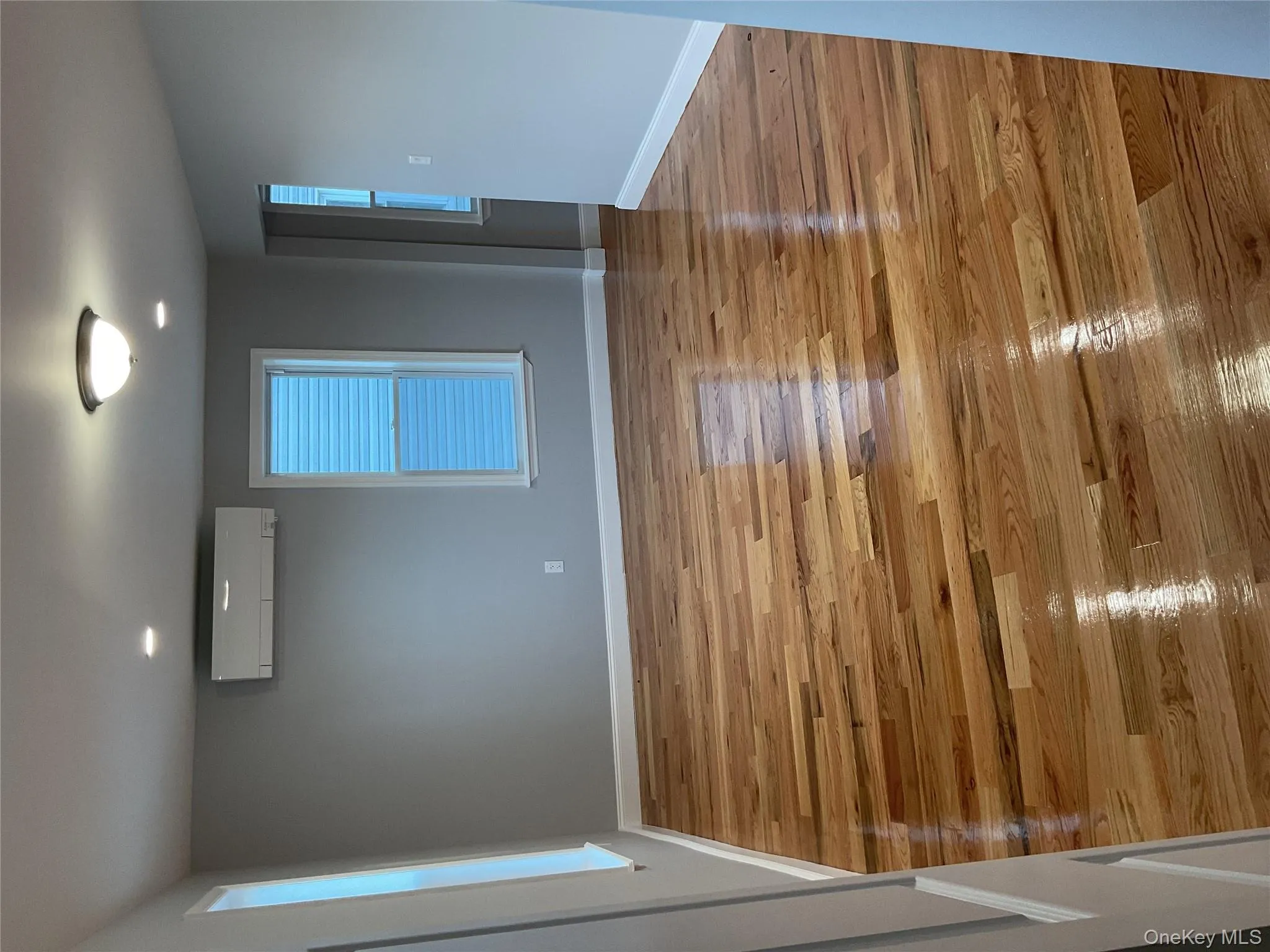 Unfurnished room with light wood finished floors, a wall unit AC, and recessed lighting Unfurnished room with light wood finished floors, a wall unit AC, and recessed lighting