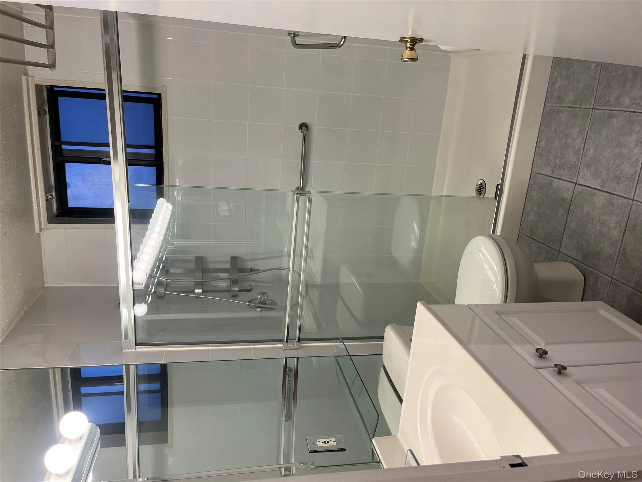 Bathroom featuring vanity, dark tile patterned floors, a shower stall, and a textured ceiling Bathroom featuring vanity, dark tile patterned floors, a shower stall, and a textured ceiling