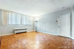 Unfurnished room featuring baseboards and radiator heating unit Unfurnished room featuring baseboards and radiator heating unit