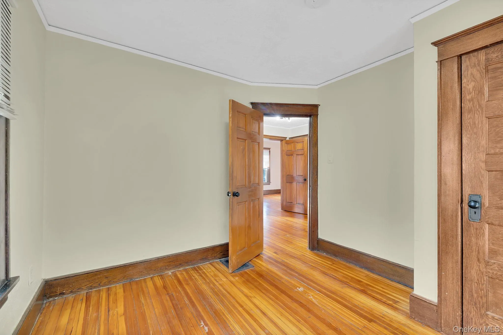 Unfurnished room featuring hardwood / wood-style flooring and crown molding Unfurnished room featuring hardwood / wood-style flooring and crown molding