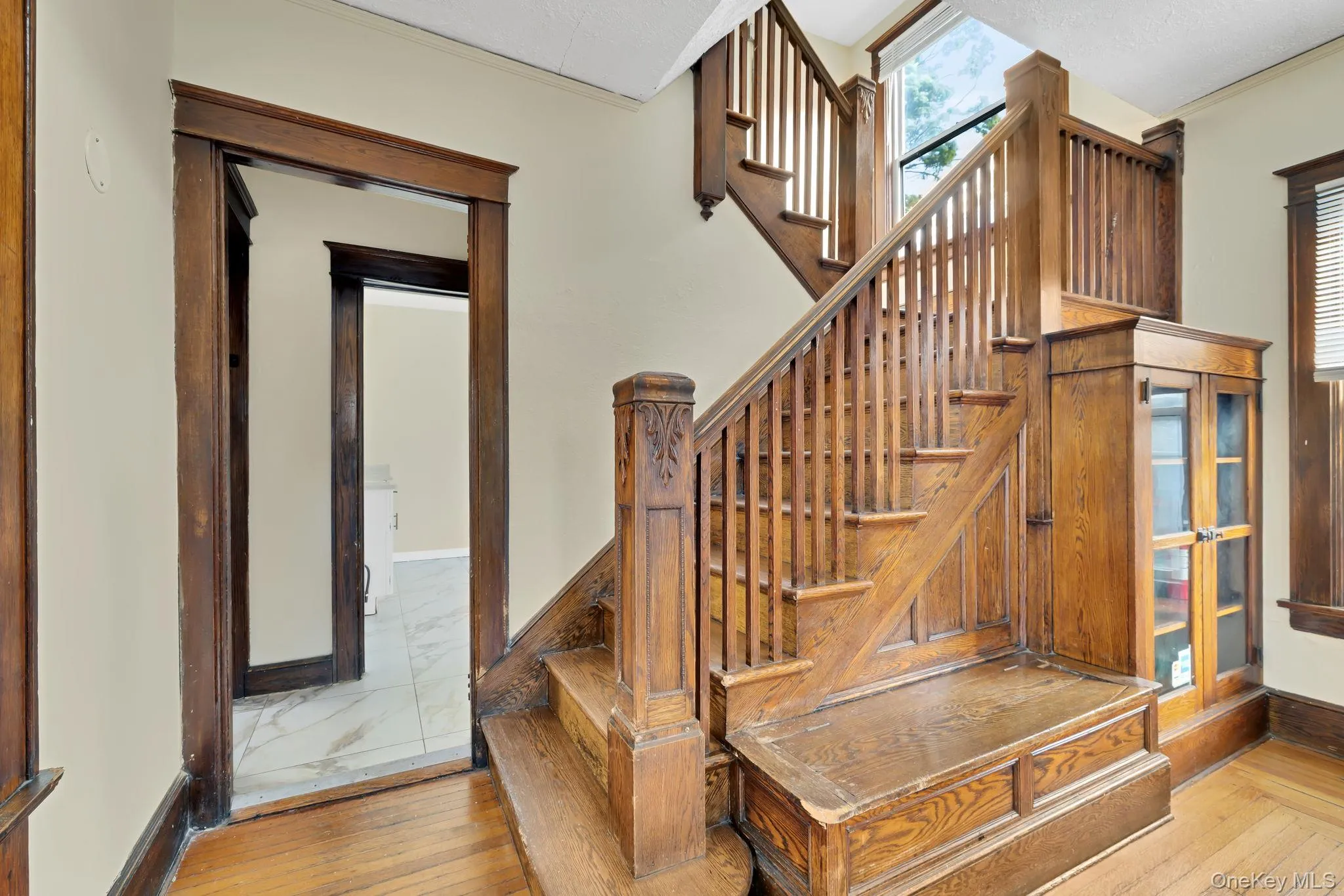 Staircase featuring plenty of natural light, hardwood / wood-style floors, and crown molding Staircase featuring plenty of natural light, hardwood / wood-style floors, and crown molding