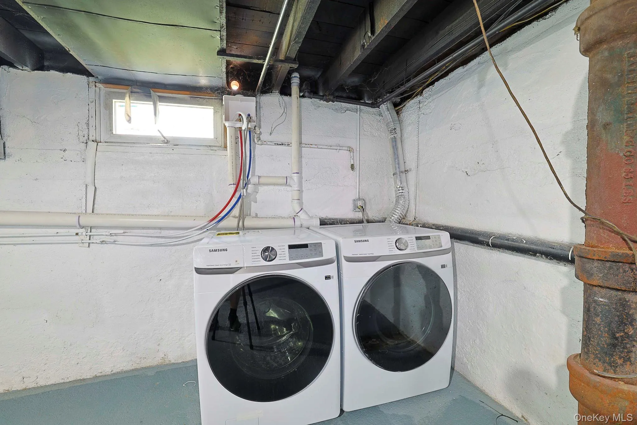 Laundry area with washing machine and clothes dryer and concrete floors Laundry area with washing machine and clothes dryer and concrete floors