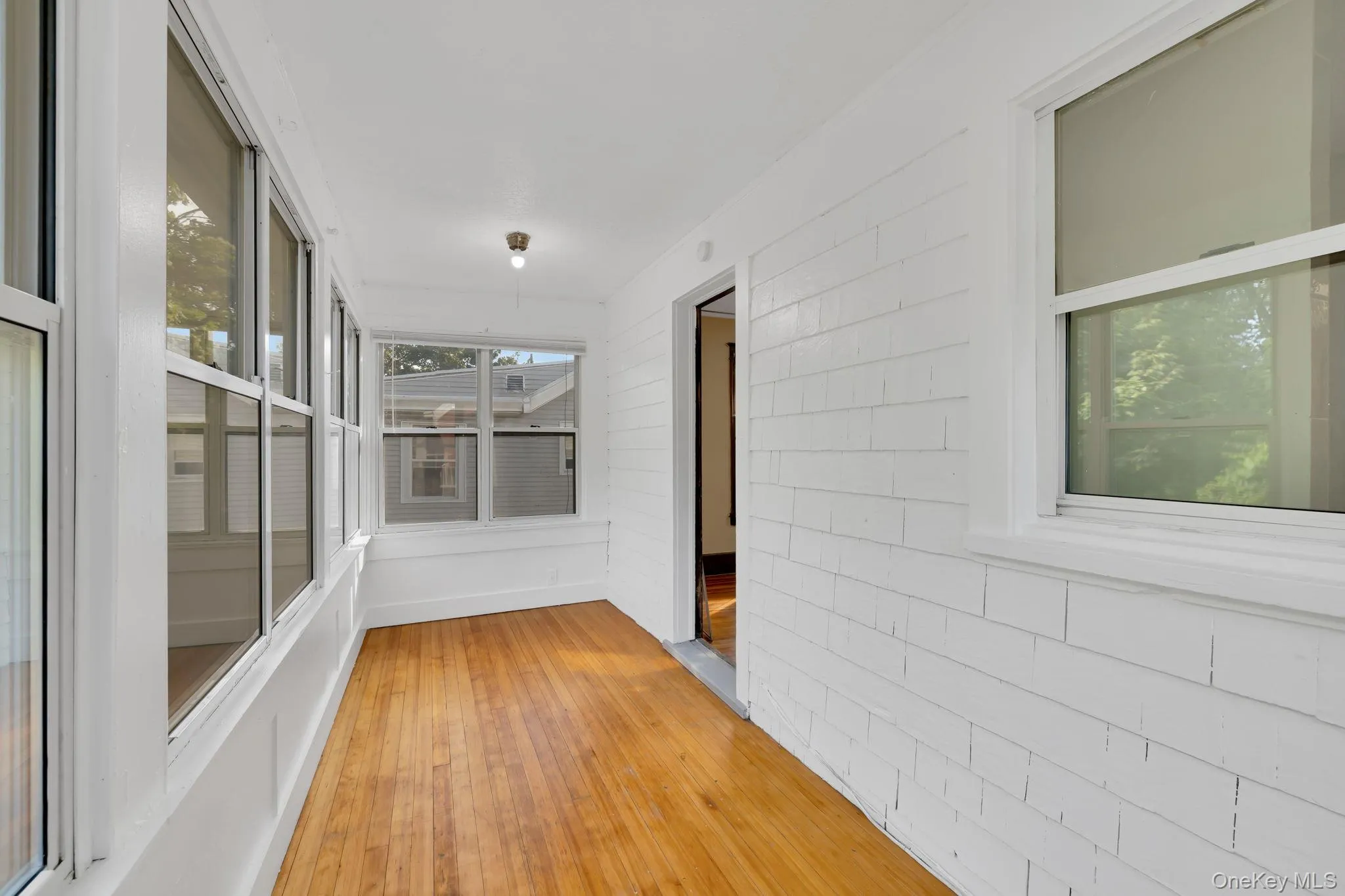 Unfurnished sunroom with hardwood / wood-style flooring Unfurnished sunroom with hardwood / wood-style flooring