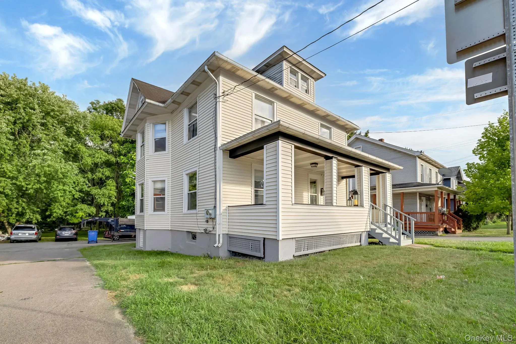 View of side of property featuring a porch and a yard View of side of property featuring a porch and a yard