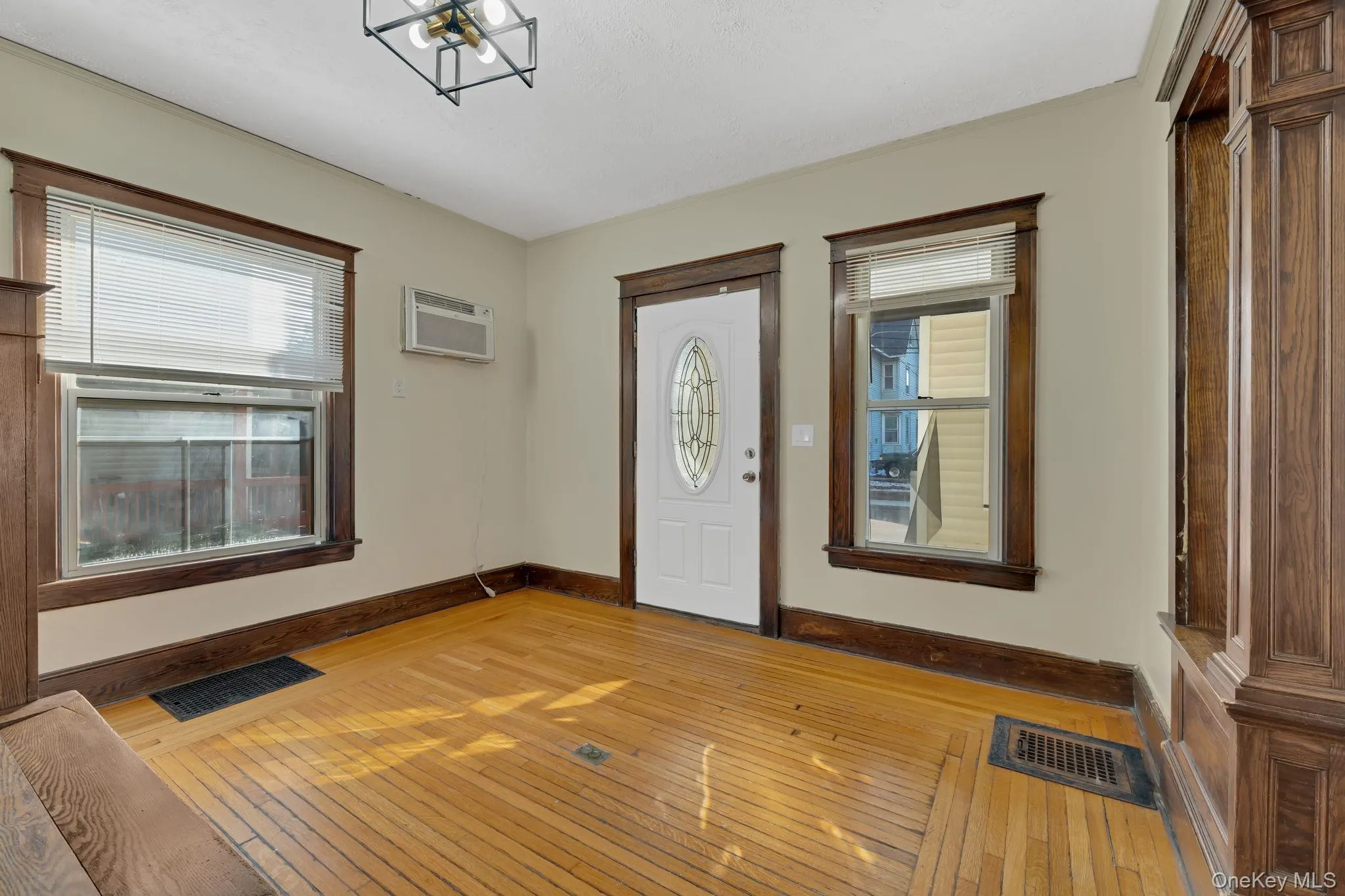 Foyer with hardwood / wood-style flooring, a wall mounted AC, and a chandelier Foyer with hardwood / wood-style flooring, a wall mounted AC, and a chandelier