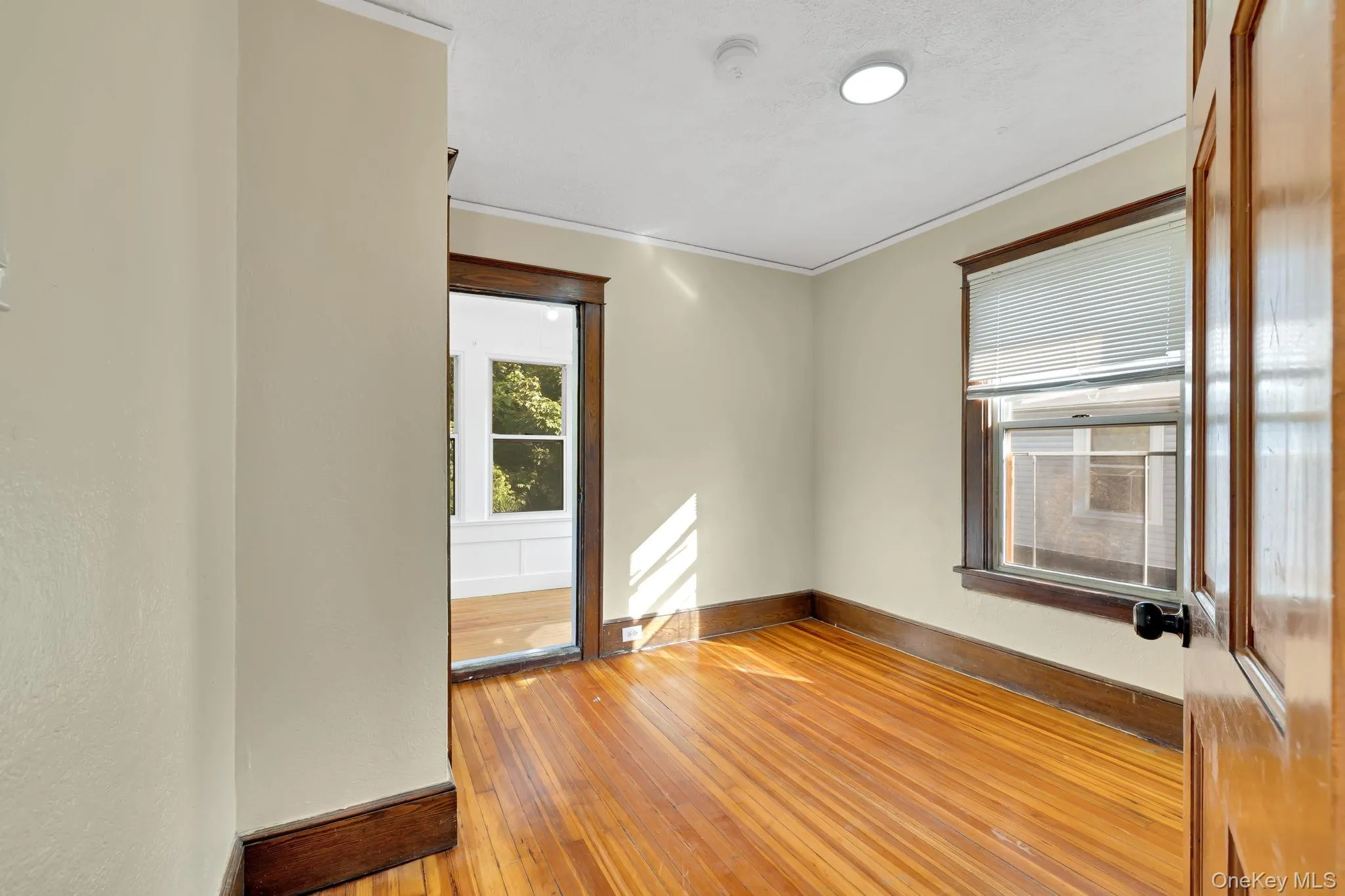 Unfurnished room with light wood finished floors and baseboards Unfurnished room with light wood finished floors and baseboards