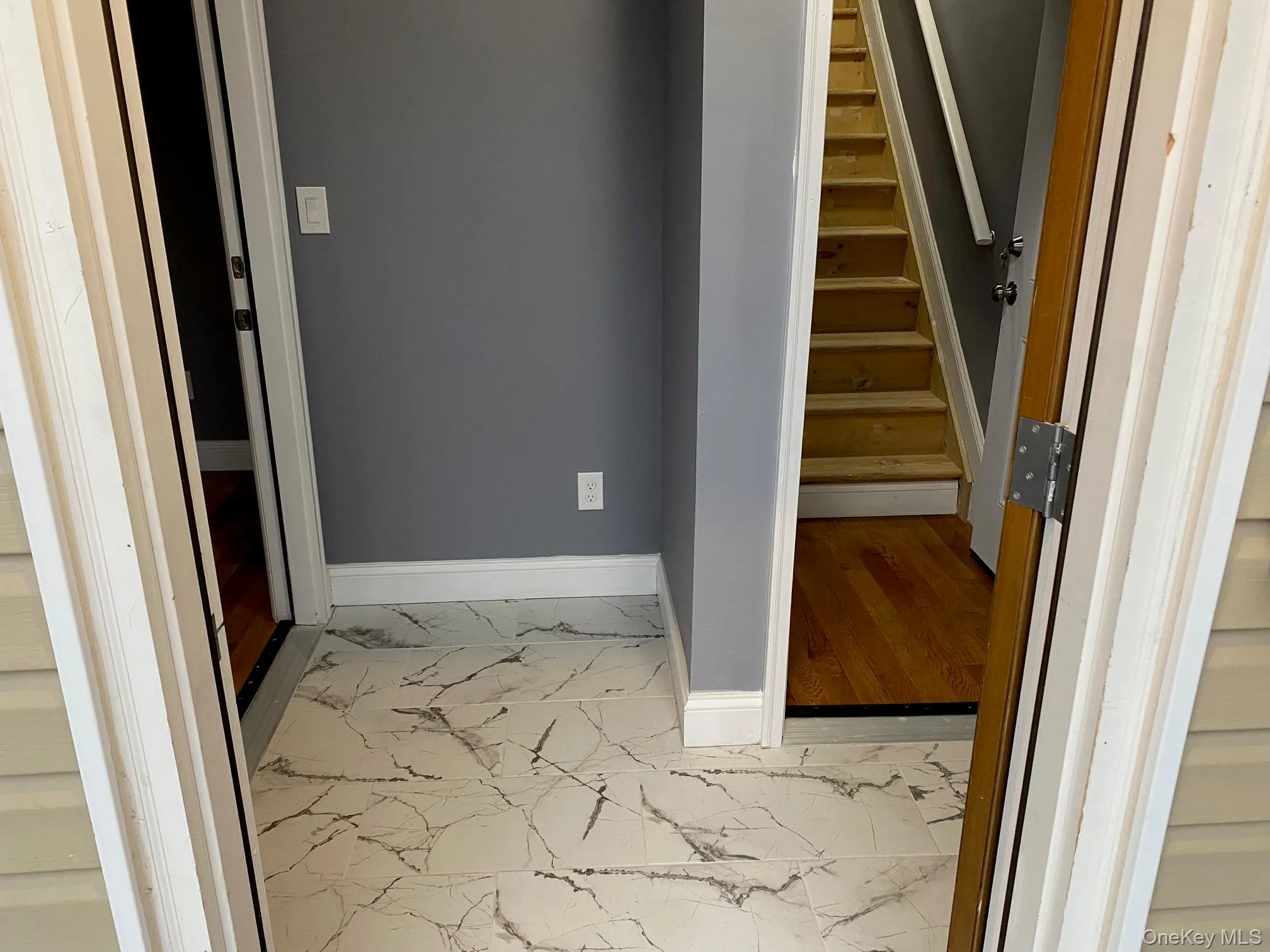 Staircase featuring marble look tiles and baseboards Staircase featuring marble look tiles and baseboards