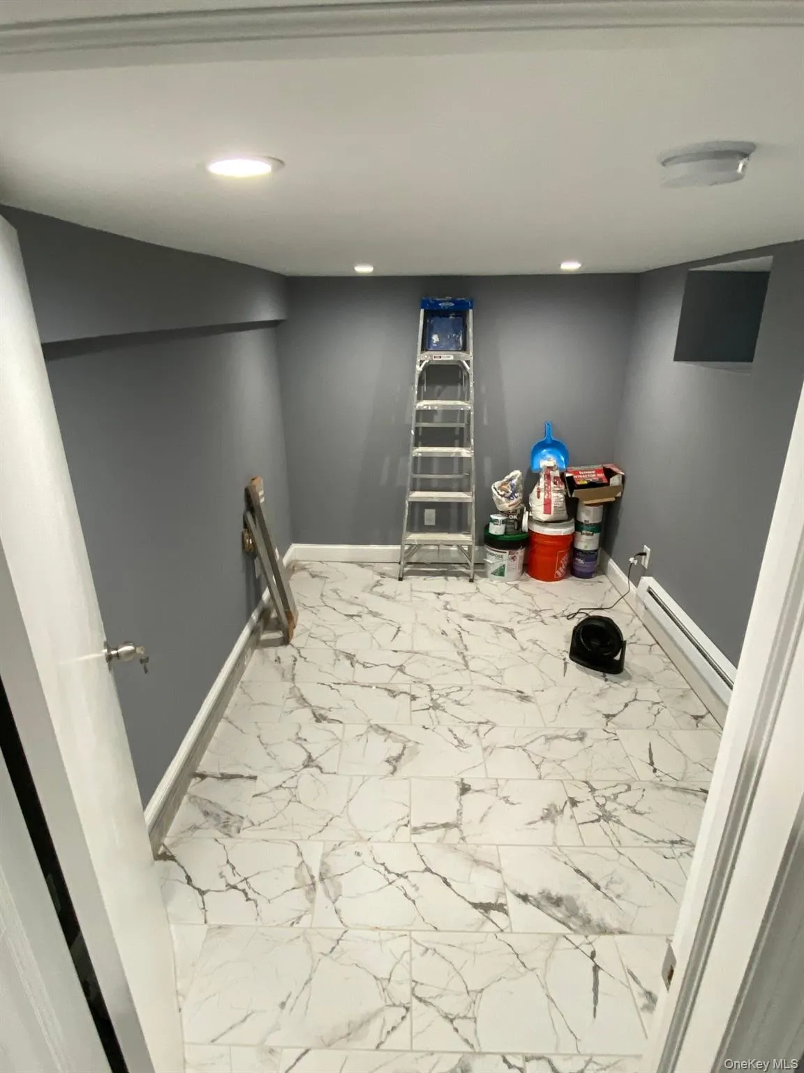 Laundry room featuring light marble finish floors, a baseboard radiator, and recessed lighting Laundry room featuring light marble finish floors, a baseboard radiator, and recessed lighting