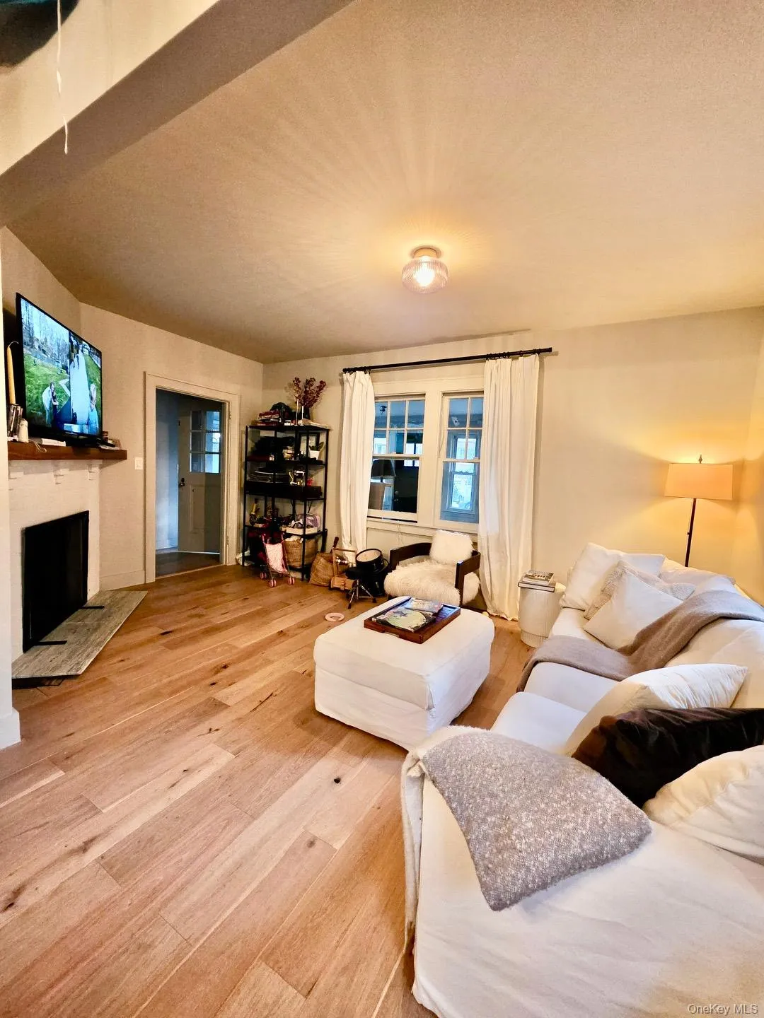 Living room with a fireplace and light wood finished floors Living room with a fireplace and light wood finished floors