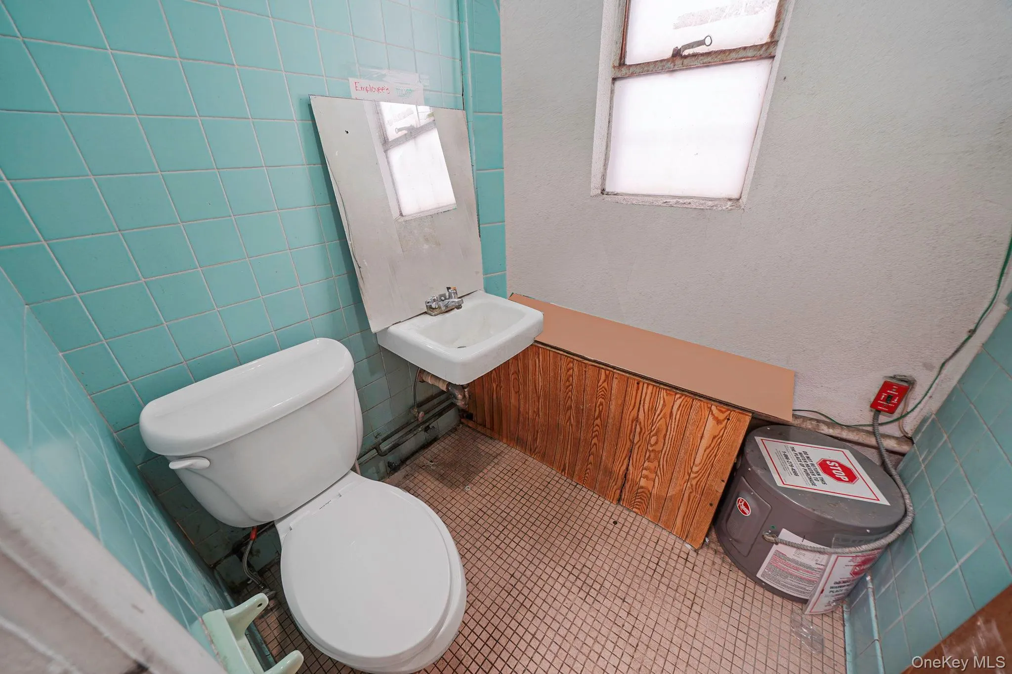 Bathroom with tile walls, tile patterned floors, and a textured wall Bathroom with tile walls, tile patterned floors, and a textured wall