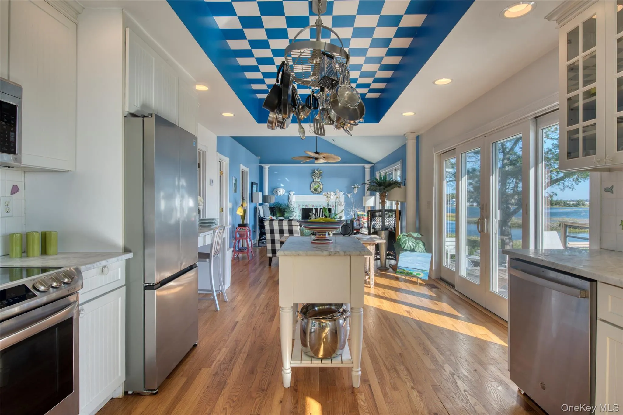 Kitchen featuring white cabinets, appliances with stainless steel finishes, light wood-style floors, light stone countertops, and recessed lighting Kitchen featuring white cabinets, appliances with stainless steel finishes, light wood-style floors, light stone countertops, and recessed lighting