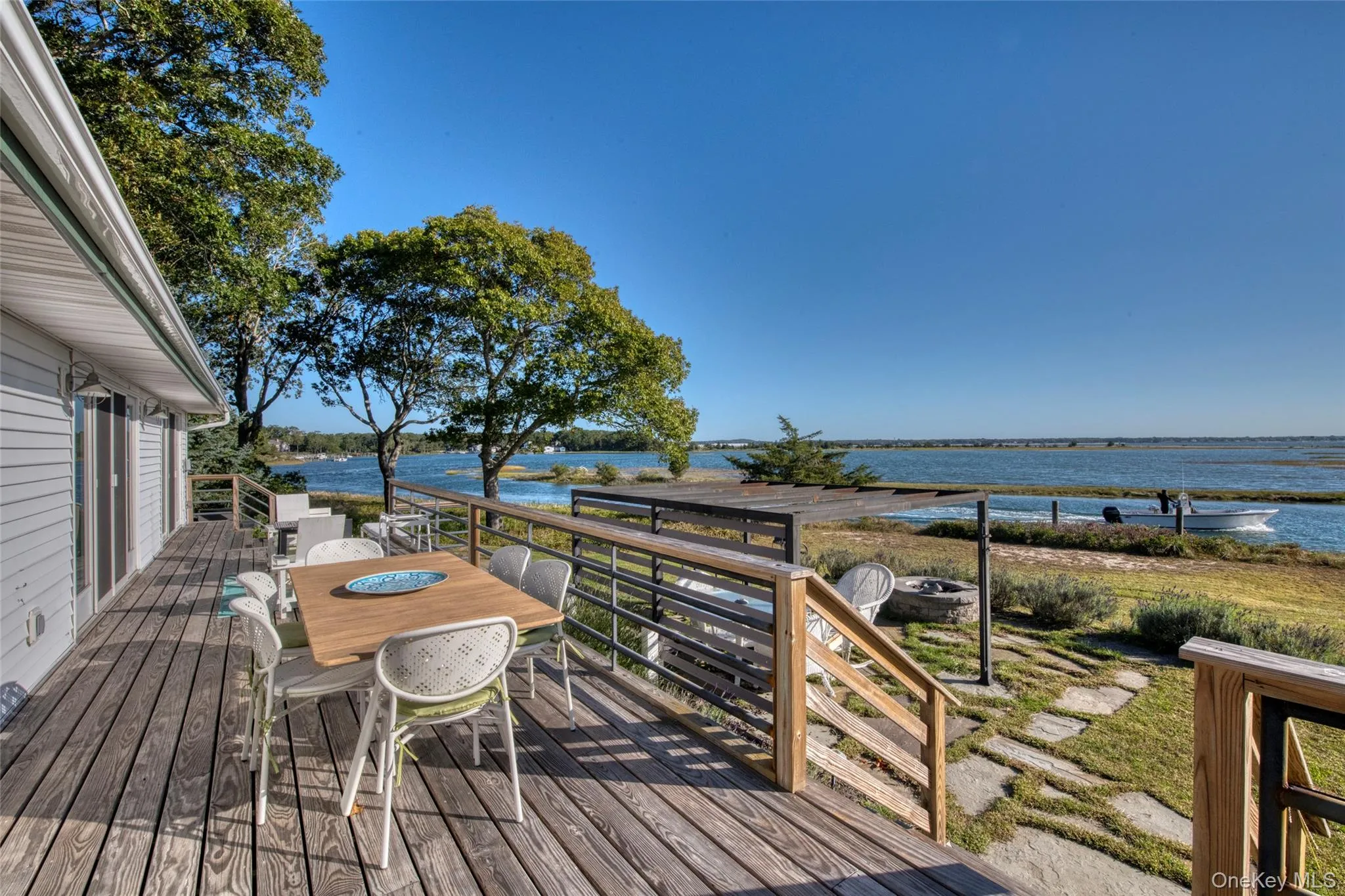 Wooden terrace featuring a water view and outdoor dining space Wooden terrace featuring a water view and outdoor dining space