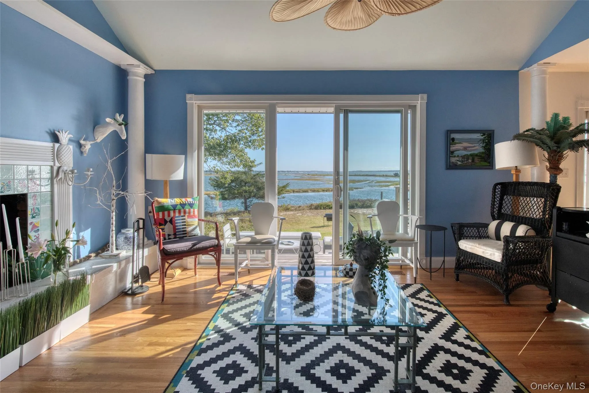 Living room with ornate columns, a water view, lofted ceiling, and plenty of natural light Living room with ornate columns, a water view, lofted ceiling, and plenty of natural light