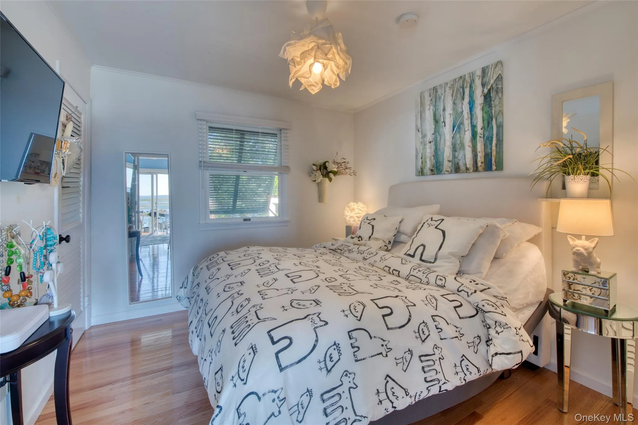 Bedroom featuring light wood-style floors and ornamental molding Bedroom featuring light wood-style floors and ornamental molding