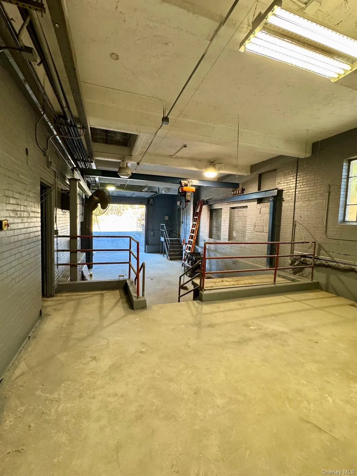 Basement with brick wall, healthy amount of natural light, and stairs Basement with brick wall, healthy amount of natural light, and stairs