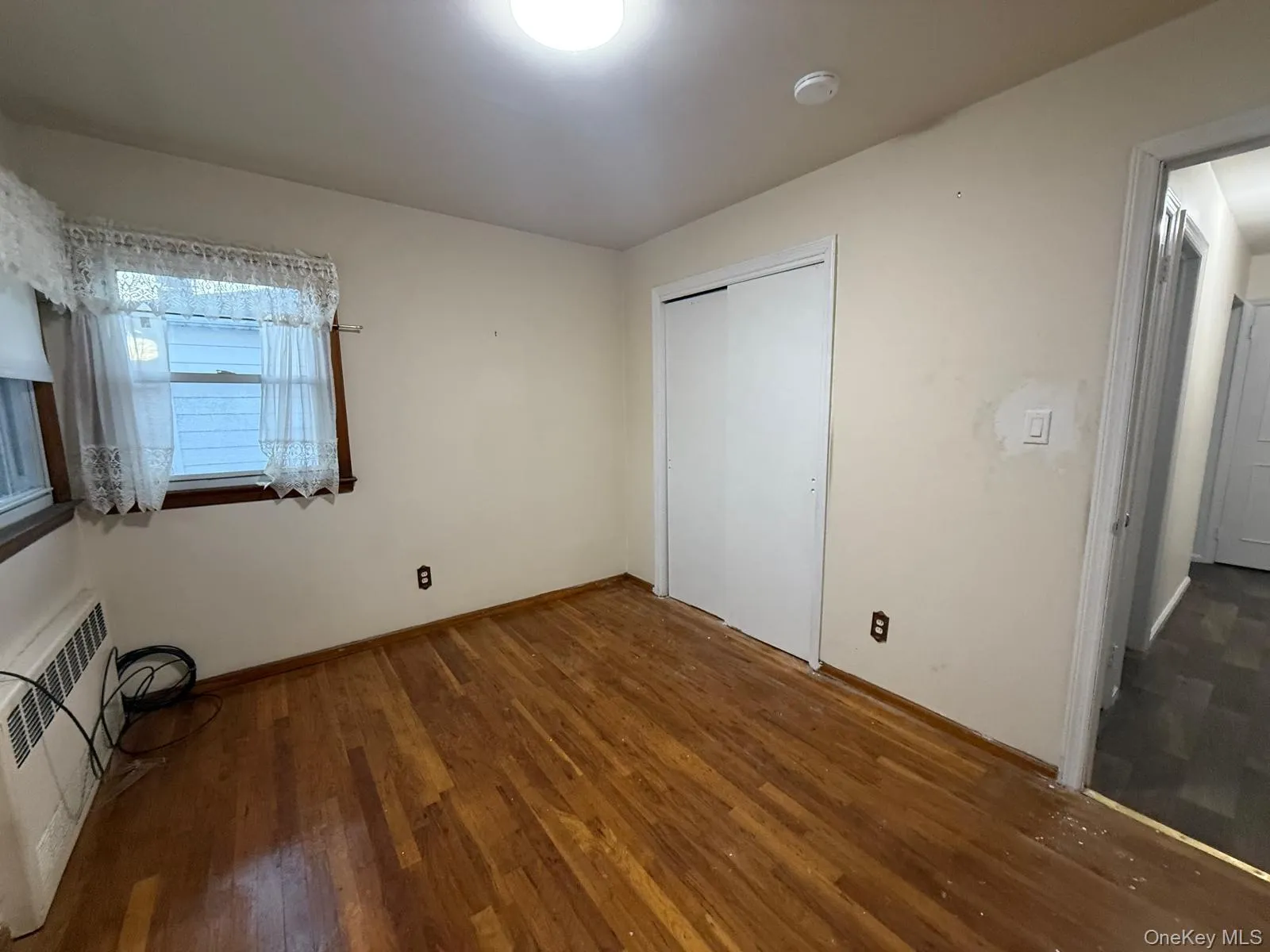 Unfurnished bedroom with dark wood-type flooring and a closet Unfurnished bedroom with dark wood-type flooring and a closet