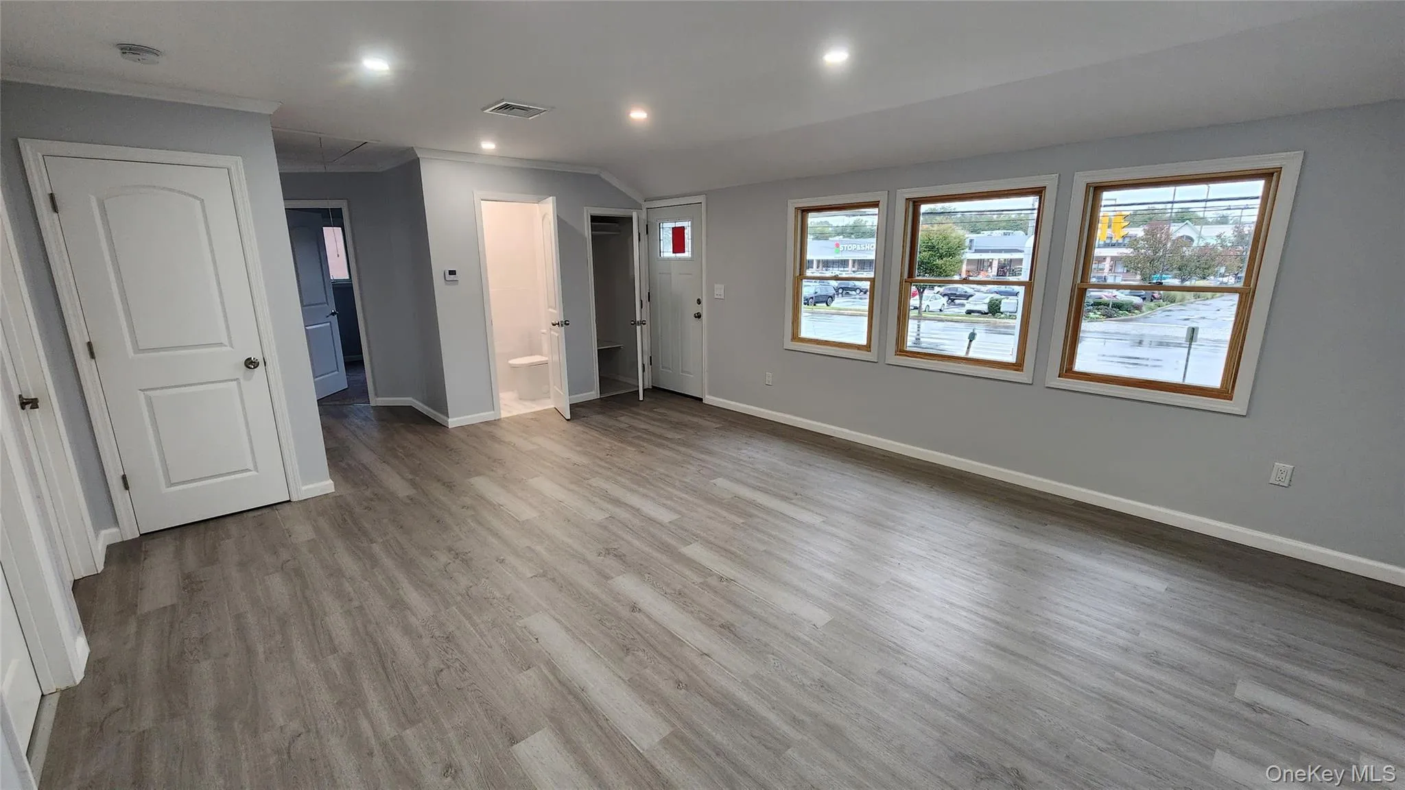 Unfurnished bedroom with attic access, ensuite bath, recessed lighting, light wood finished floors, and ornamental molding Unfurnished bedroom with attic access, ensuite bath, recessed lighting, light wood finished floors, and ornamental molding