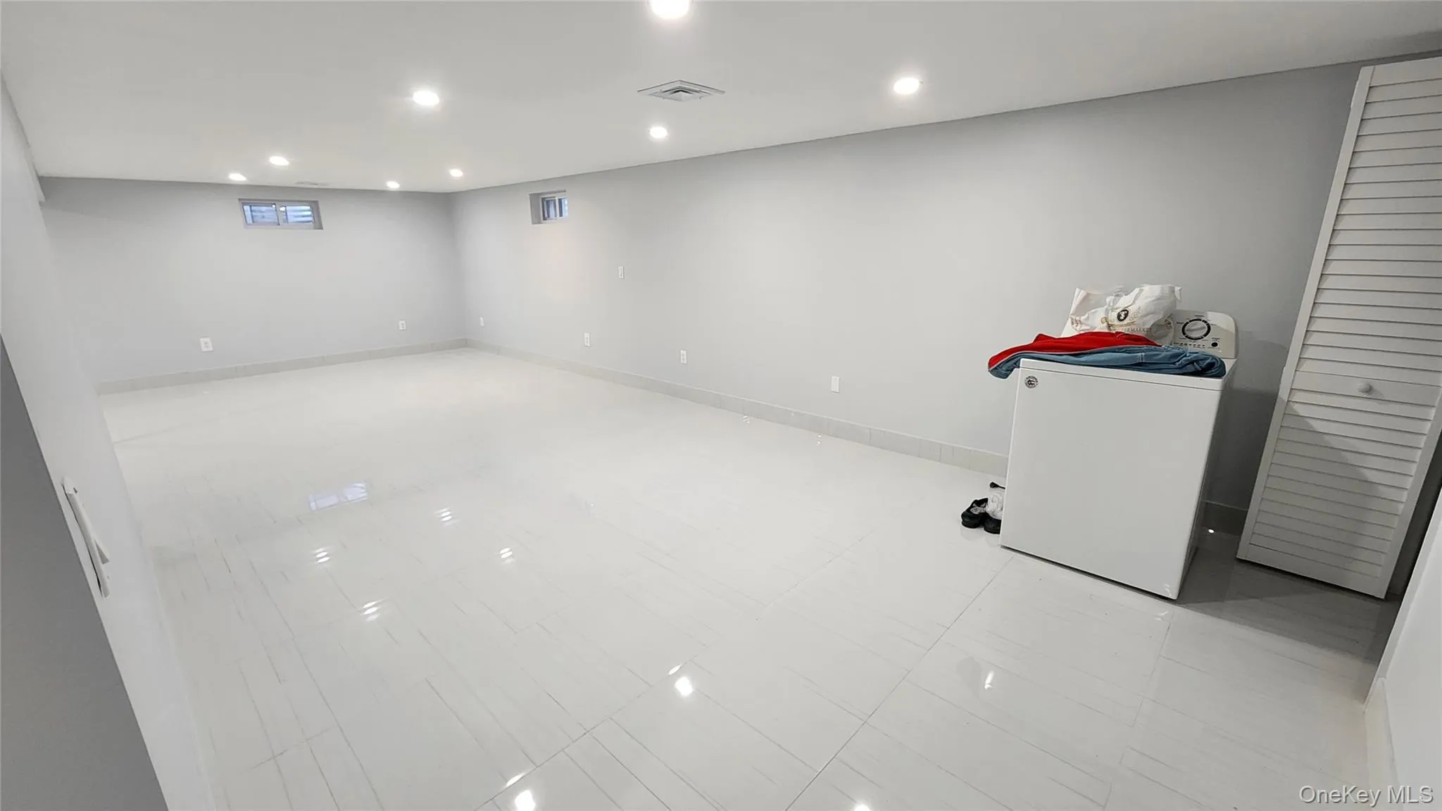 Below grade area featuring recessed lighting and washer / clothes dryer Below grade area featuring recessed lighting and washer / clothes dryer