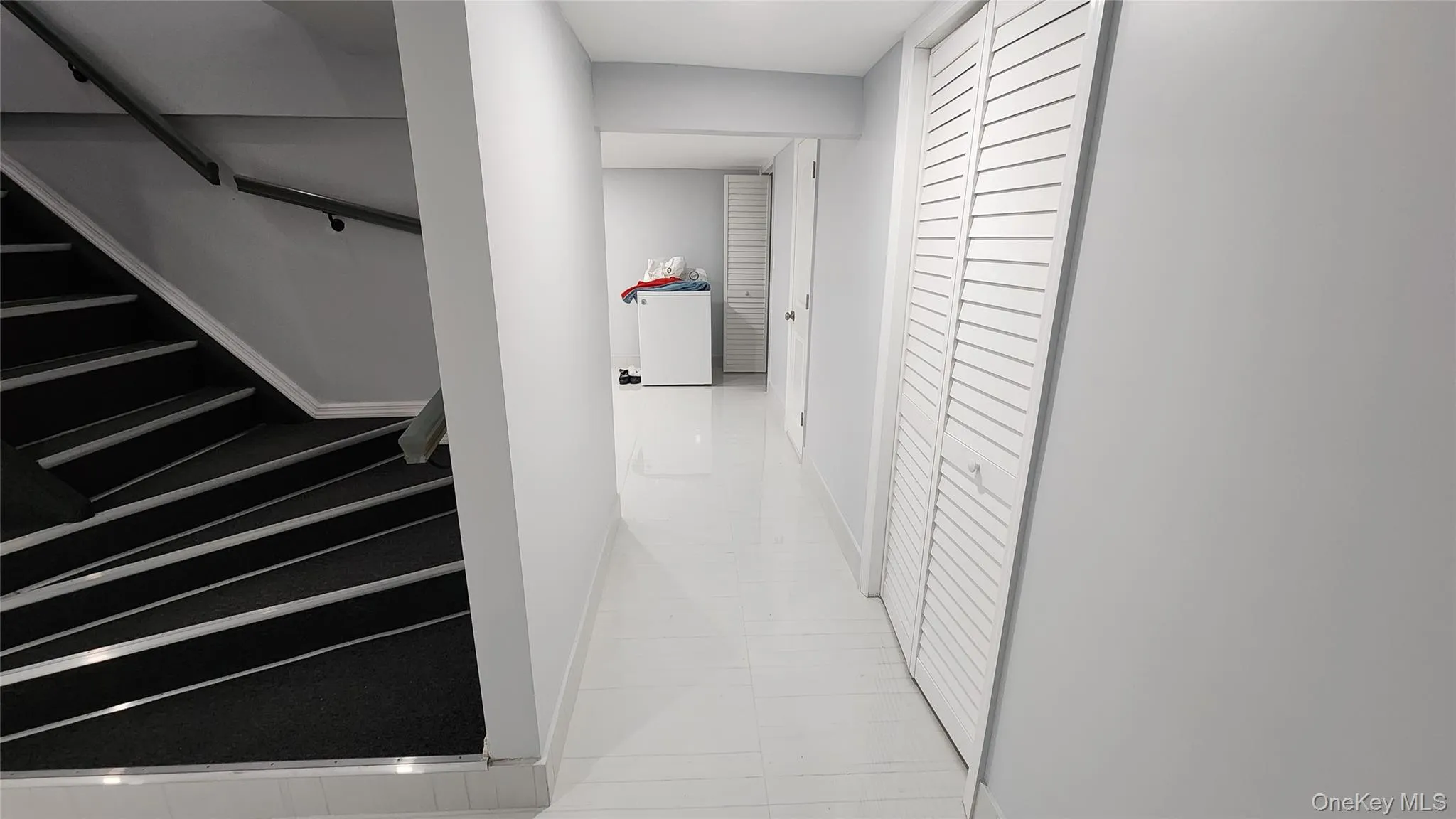 Corridor featuring light tile patterned flooring and stairway Corridor featuring light tile patterned flooring and stairway