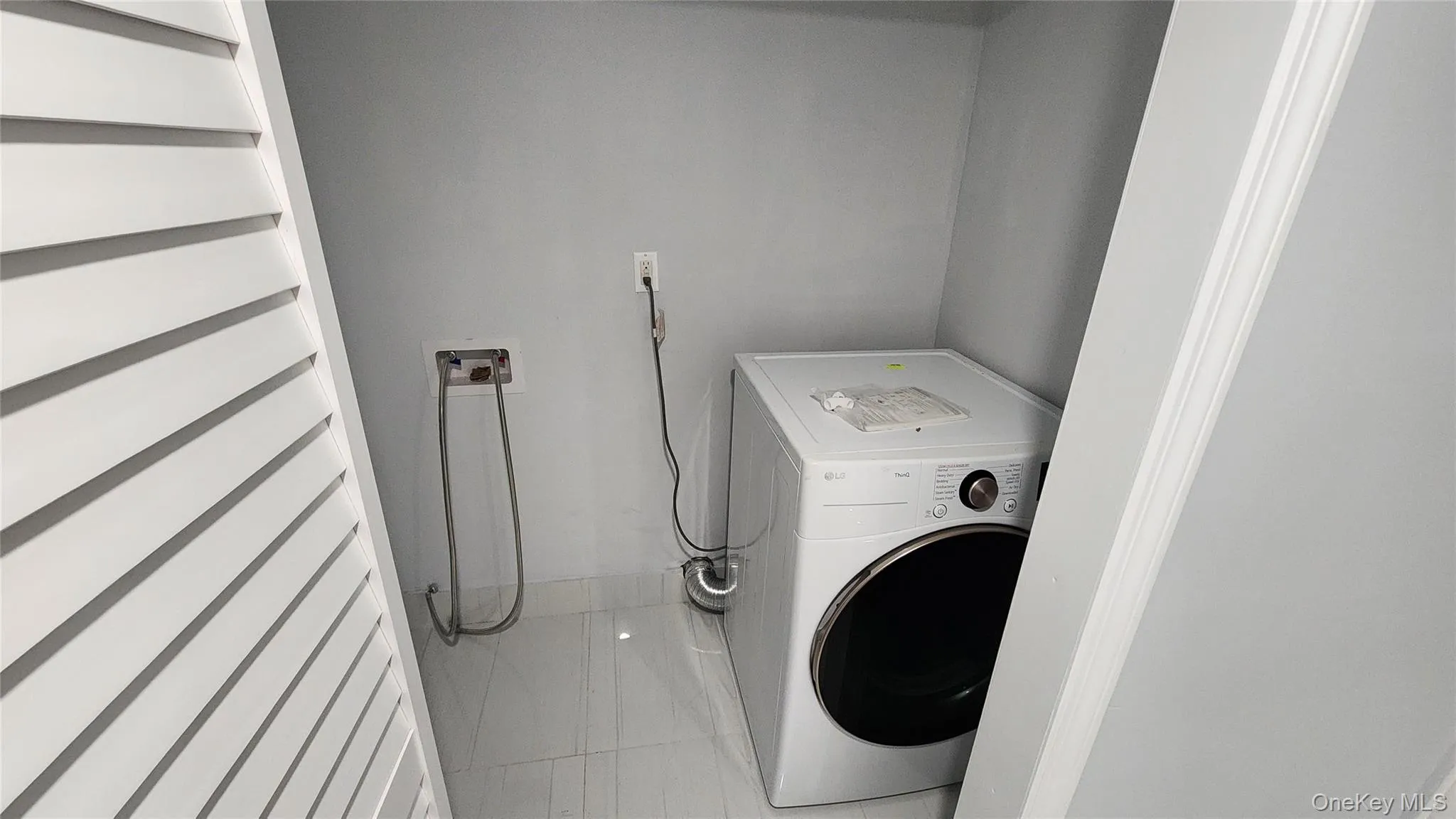 Laundry room featuring washer / clothes dryer and tile patterned floors Laundry room featuring washer / clothes dryer and tile patterned floors