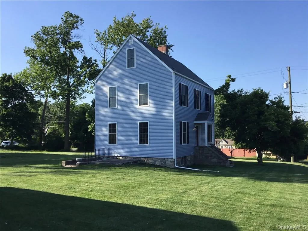 View of home's exterior with a lawn and a chimney View of home's exterior with a lawn and a chimney