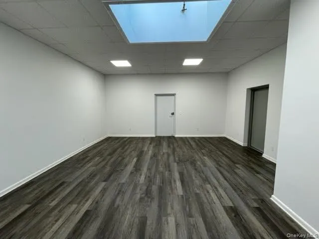 Spare room featuring a paneled ceiling and dark wood finished floors Spare room featuring a paneled ceiling and dark wood finished floors