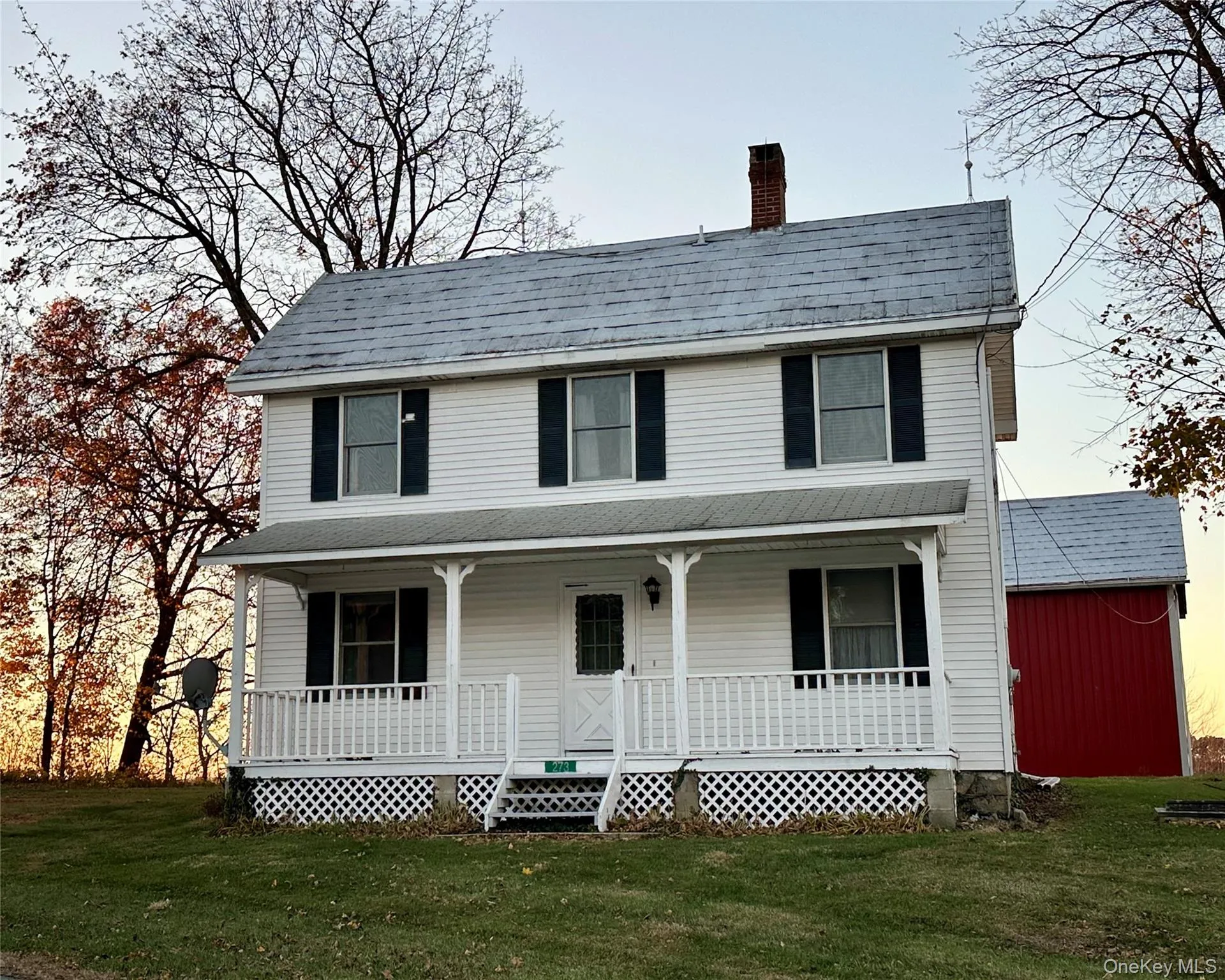 View of front of property with covered porch, a chimney, a front lawn, and a shingled roof View of front of property with covered porch, a chimney, a front lawn, and a shingled roof