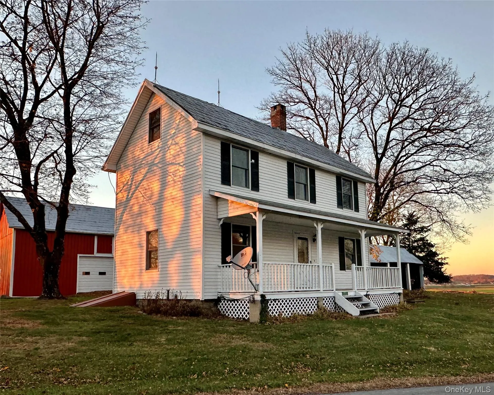 View of front of home featuring a front yard, a porch, and a chimney View of front of home featuring a front yard, a porch, and a chimney