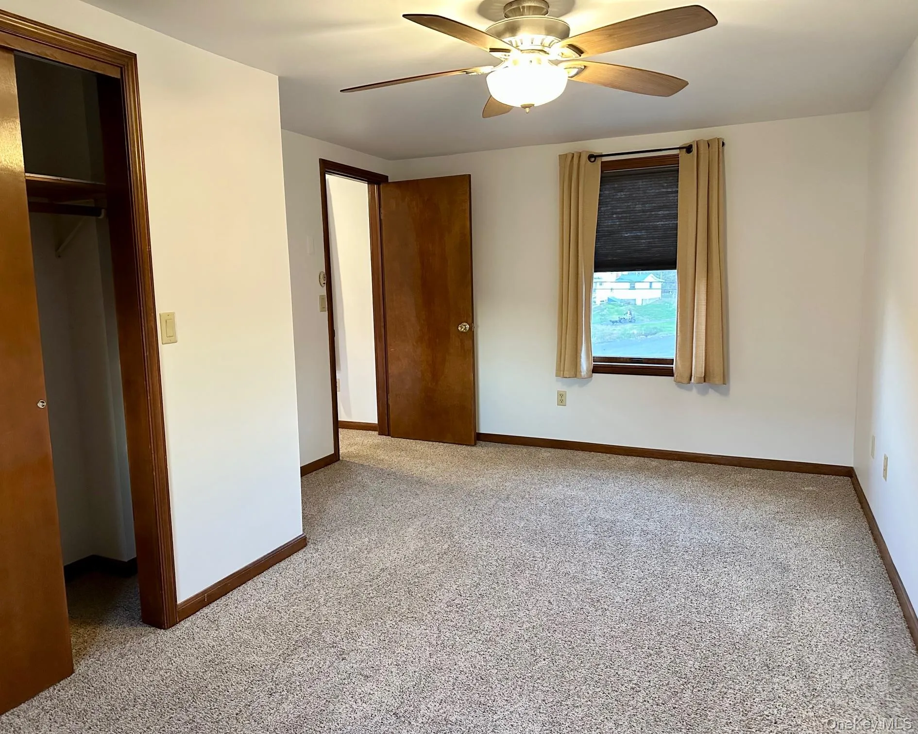 Unfurnished bedroom with light colored carpet, a closet, and a ceiling fan Unfurnished bedroom with light colored carpet, a closet, and a ceiling fan