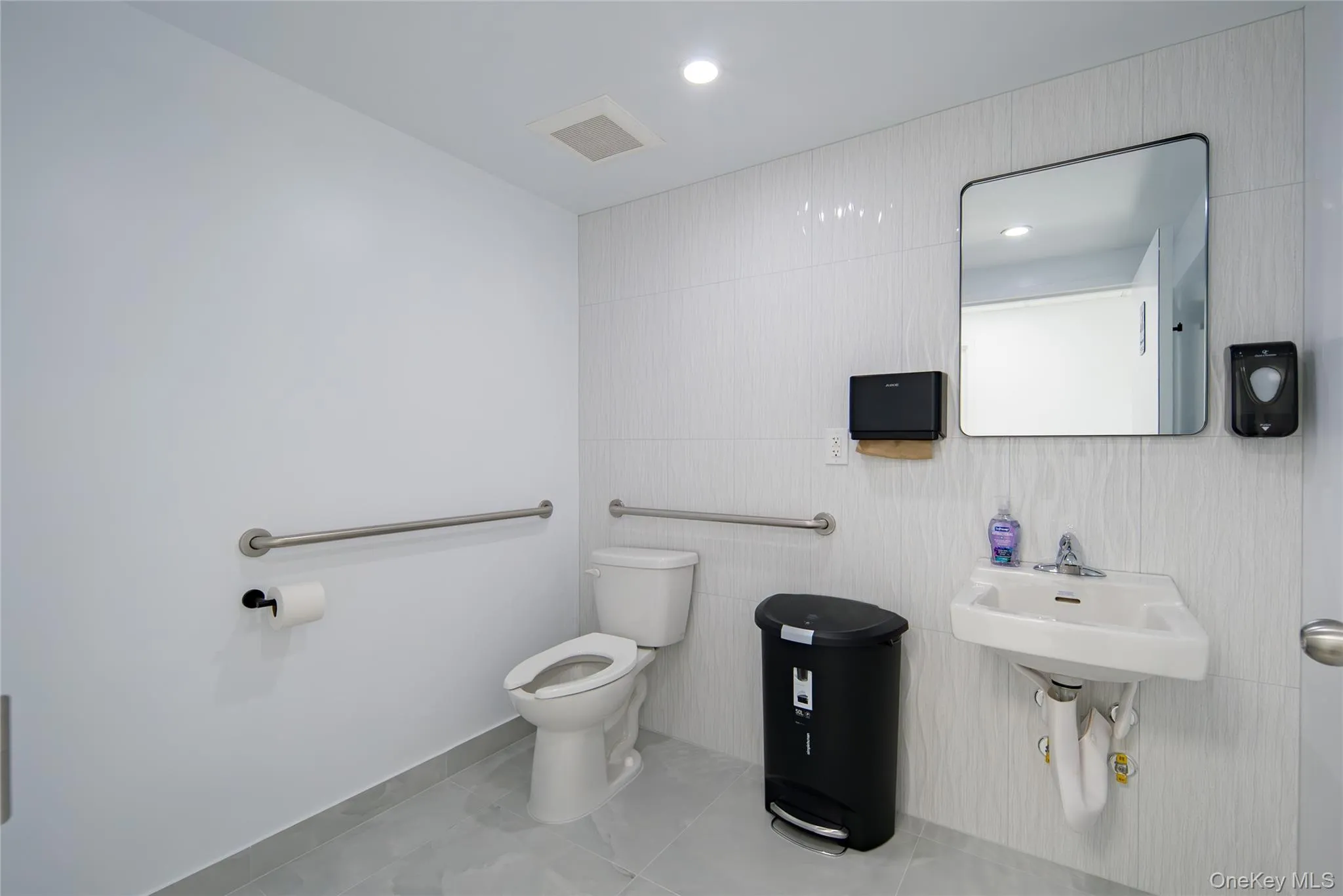 Half bath featuring light tile patterned floors, recessed lighting, and tile walls Half bath featuring light tile patterned floors, recessed lighting, and tile walls