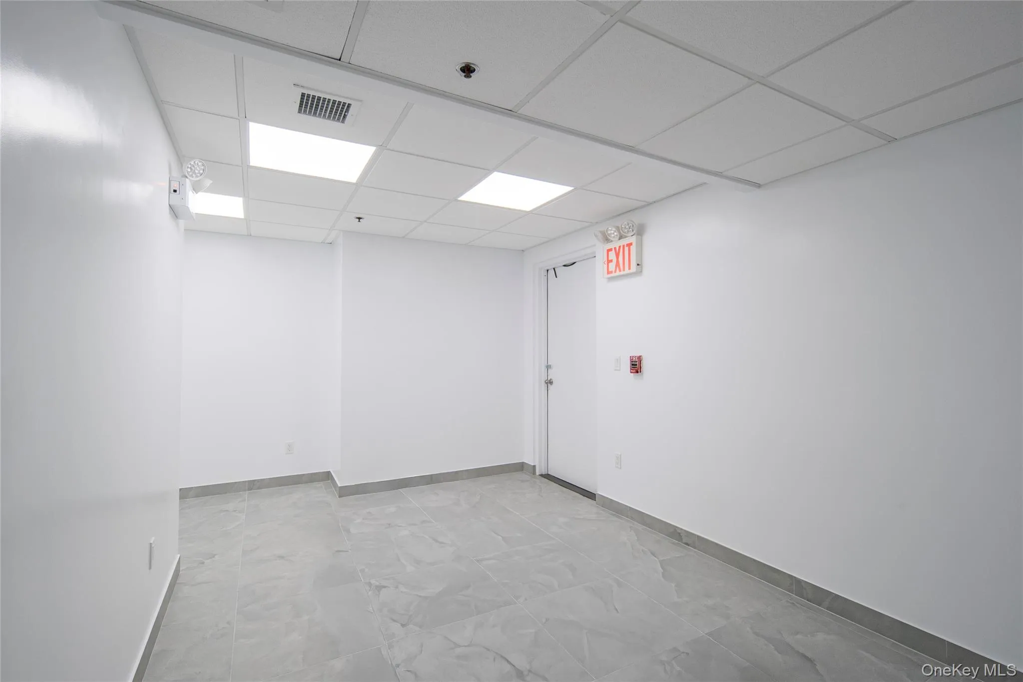 Spare room with baseboards and a paneled ceiling Spare room with baseboards and a paneled ceiling