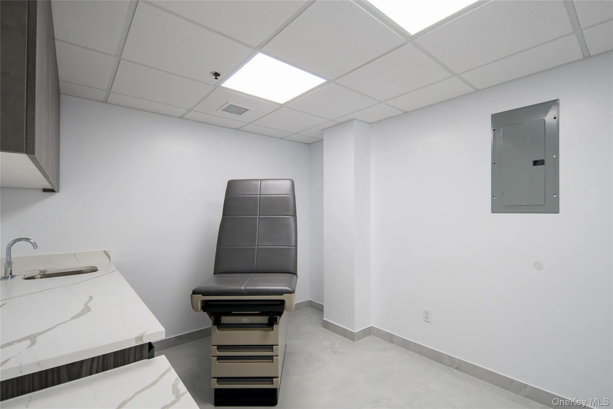 Miscellaneous room featuring electric panel and a paneled ceiling Miscellaneous room featuring electric panel and a paneled ceiling