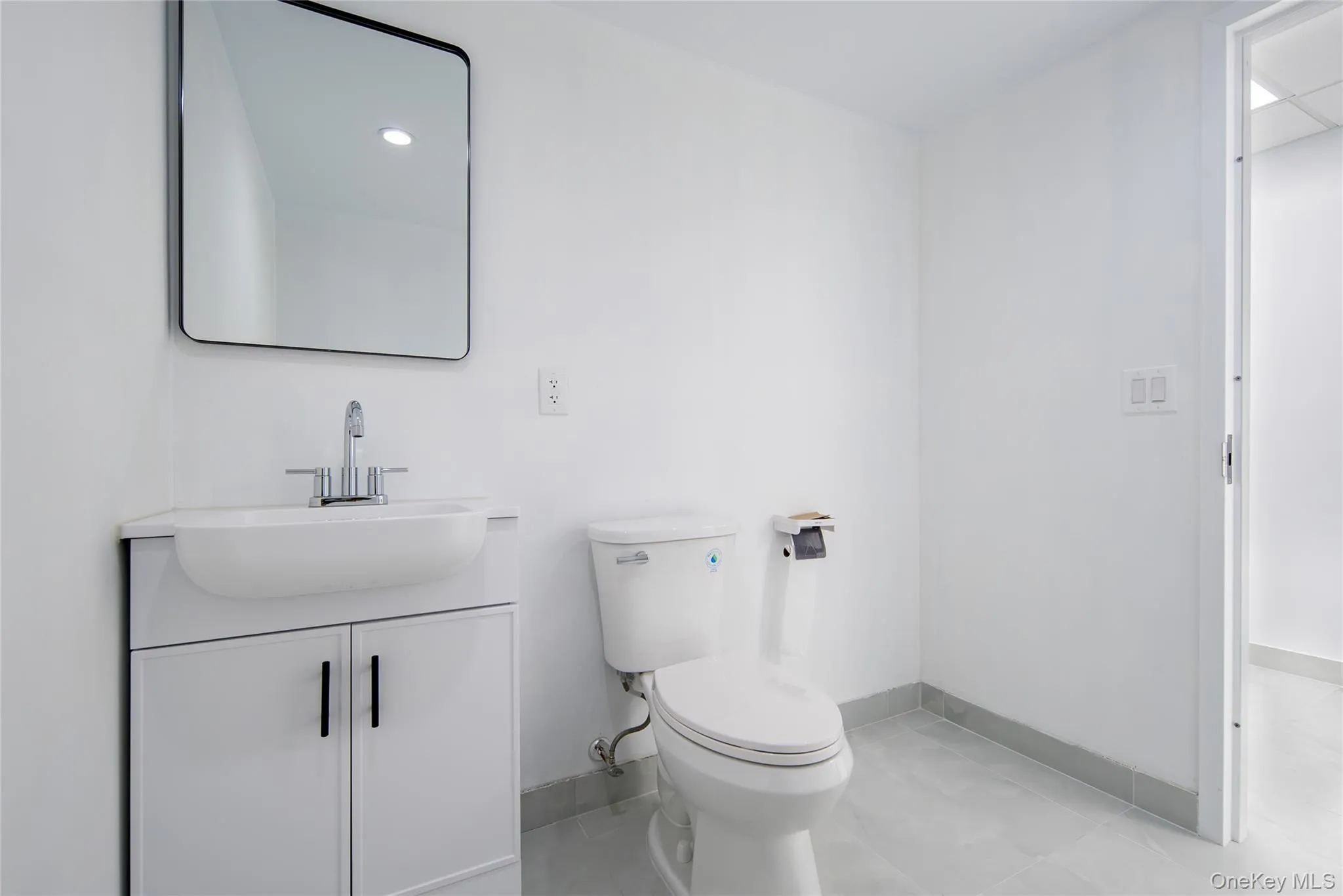 Bathroom featuring vanity and light tile patterned flooring Bathroom featuring vanity and light tile patterned flooring