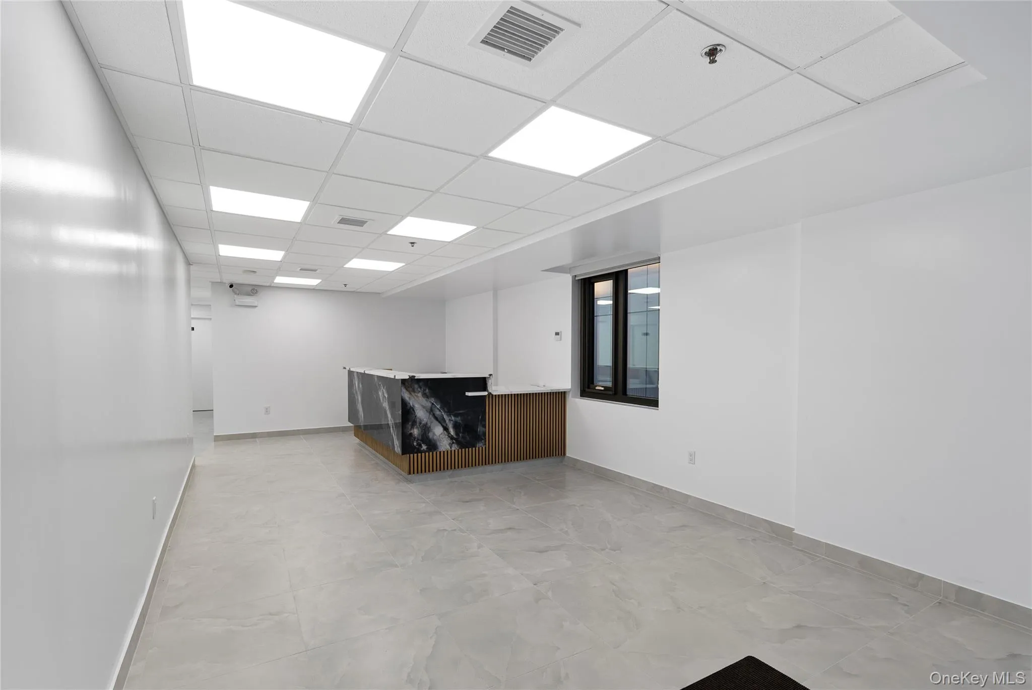 Empty room with baseboards and a paneled ceiling Empty room with baseboards and a paneled ceiling