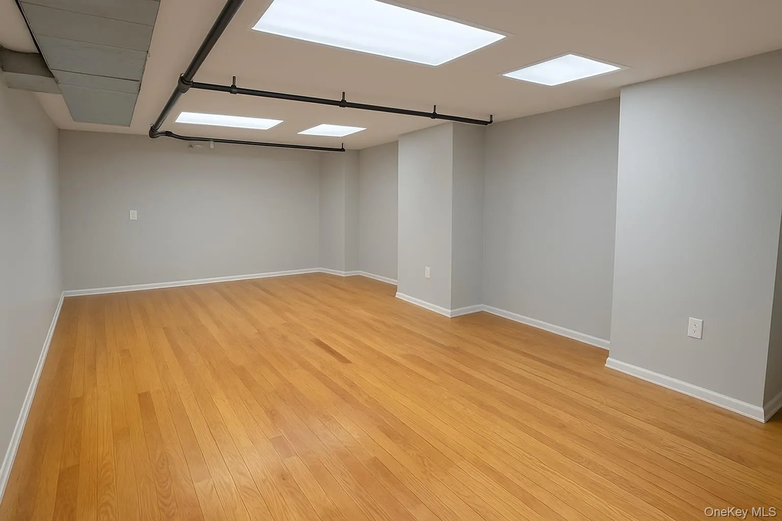 Unfurnished room with baseboards and light wood-style flooring Unfurnished room with baseboards and light wood-style flooring
