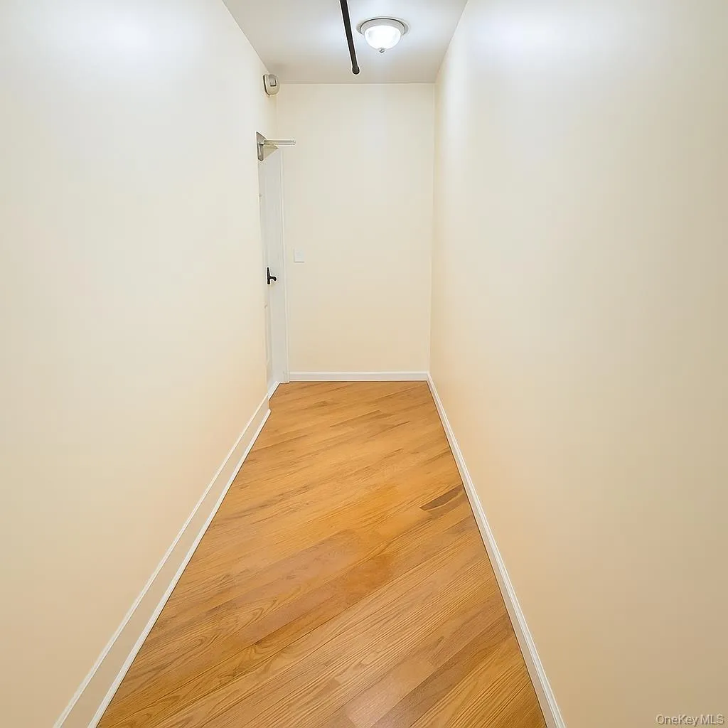 Hall featuring light wood-style floors and baseboards Hall featuring light wood-style floors and baseboards